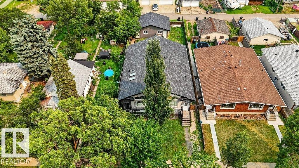 Aerial perspective of a property featuring a dark grey shingled roof, a front entrance with a porch, and mature trees surrounding the perimeter - 12219 89 Street Nw, Edmonton, AB - Outdoor