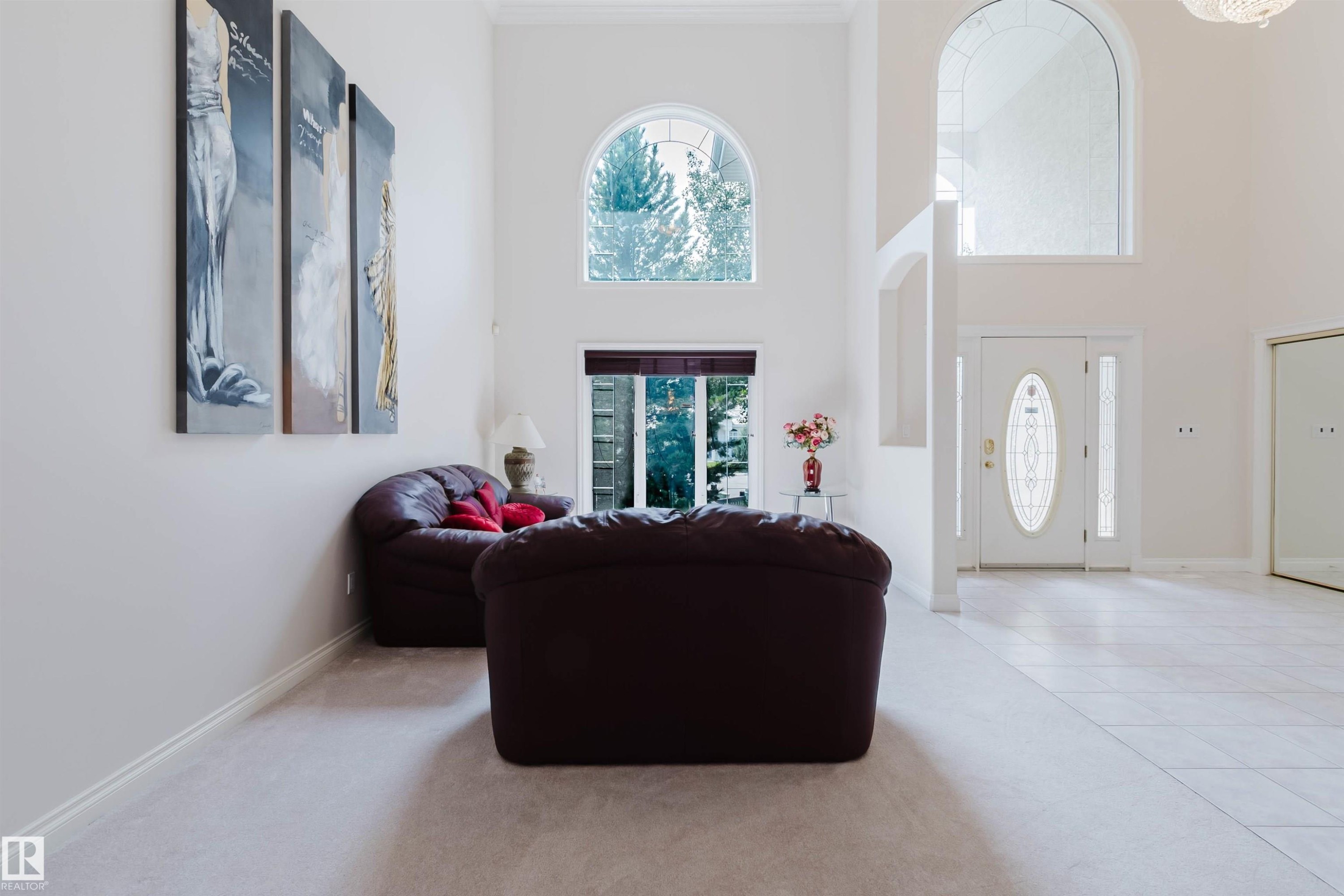 Bright foyer showcasing soaring ceilings, abundant natural light from arched transom windows, and pristine light-toned flooring - 928 Heacock Road Nw, Edmonton, AB - Indoor Photo Showing Other Room