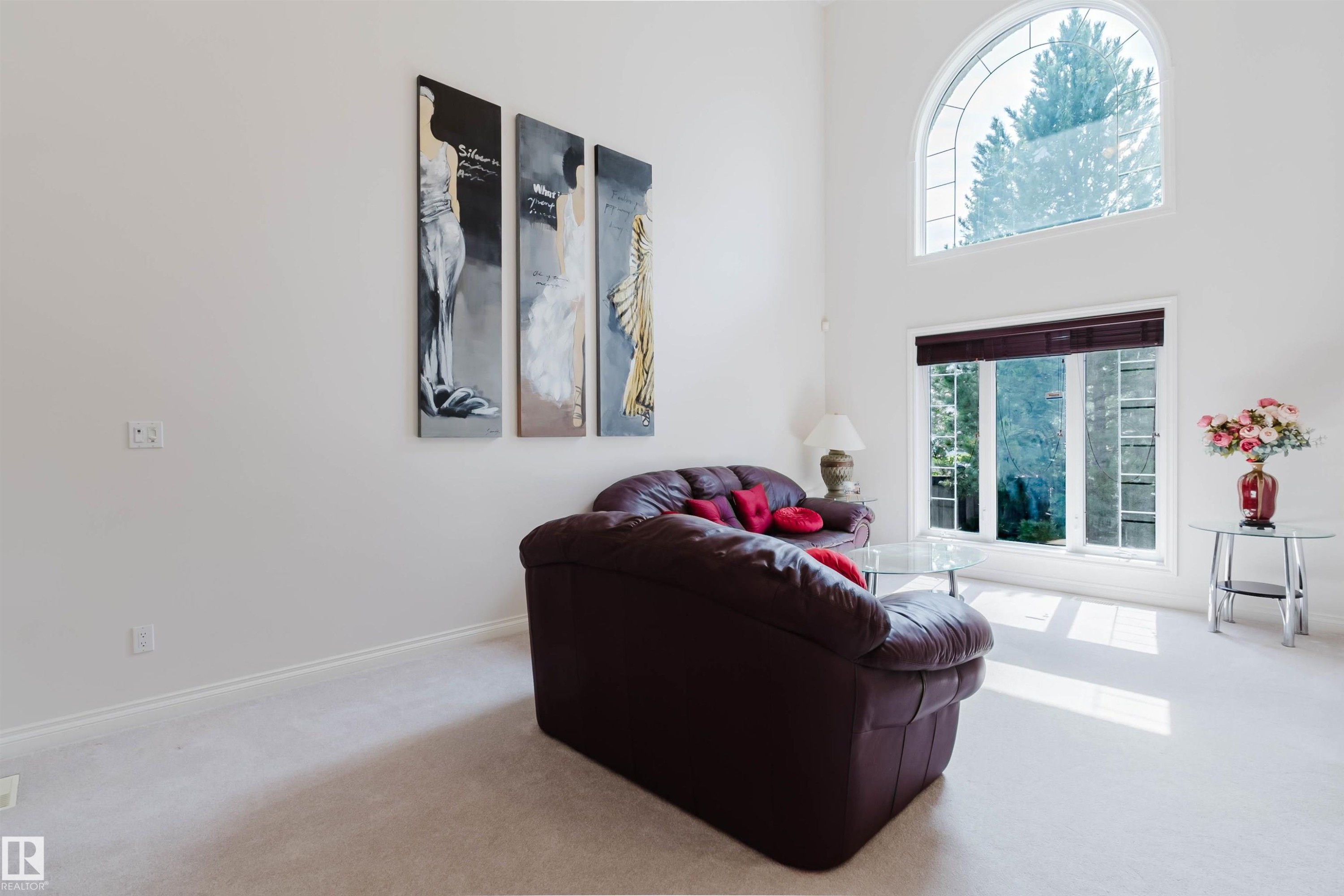 Living area featuring vaulted ceilings and an arched window - 928 Heacock Road Nw, Edmonton, AB - Indoor