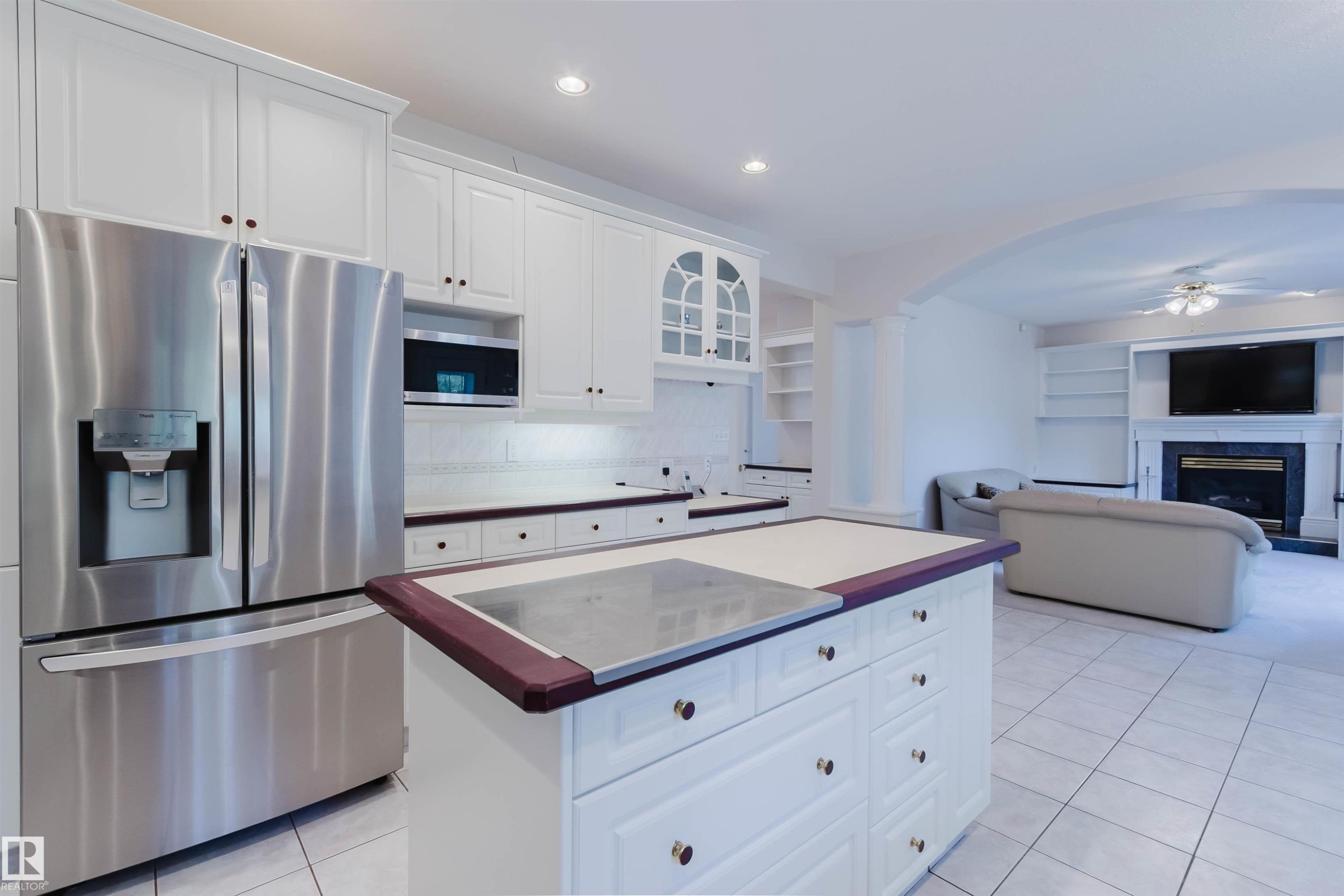 Kitchen featuring white cabinetry with gold-toned hardware, stainless steel appliances, and a central island with a contrasting countertop - 928 Heacock Road Nw, Edmonton, AB - Indoor Photo Showing Kitchen