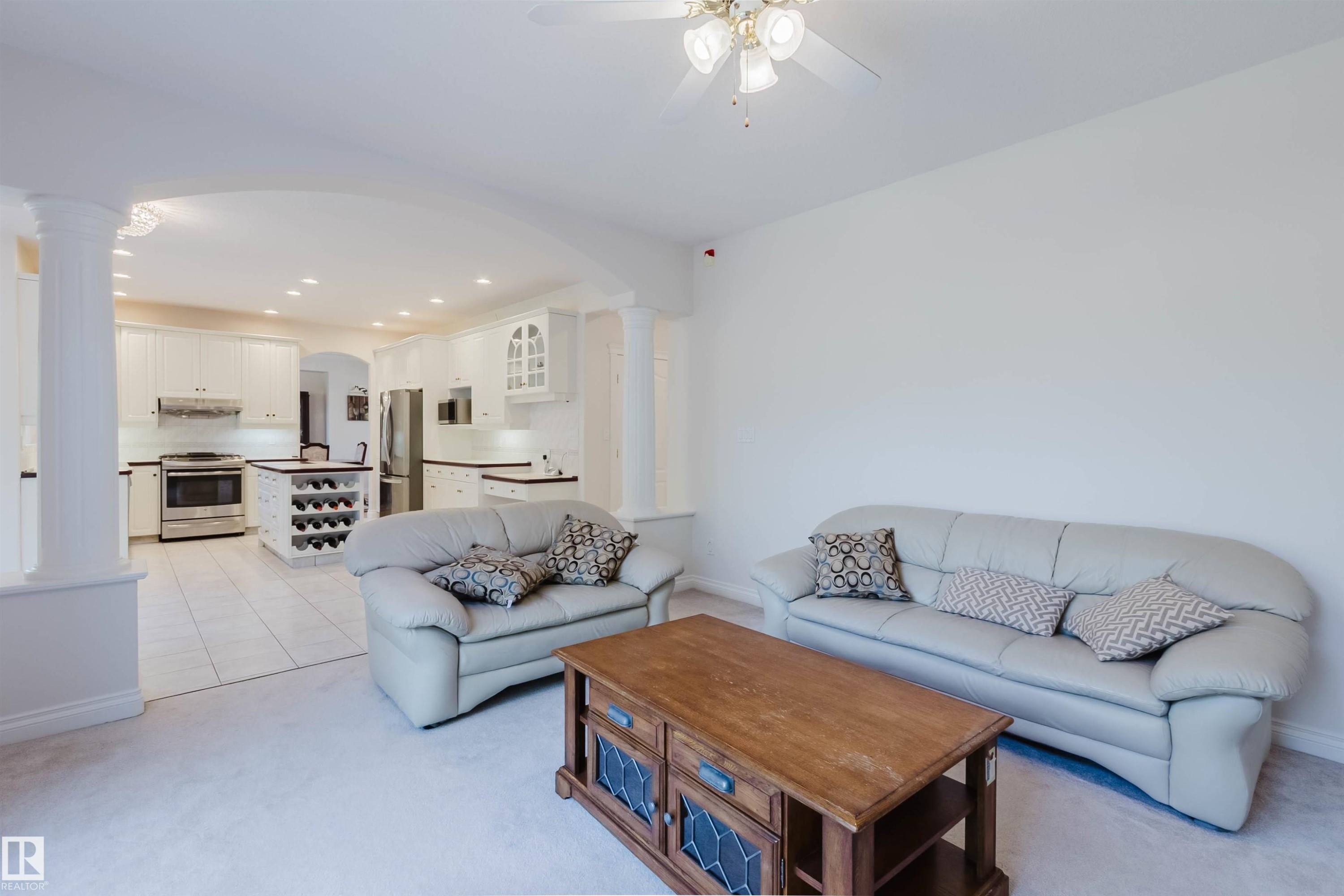 Expansive open-concept living area featuring light-toned carpeting and a ceiling fan - 928 Heacock Road Nw, Edmonton, AB - Indoor Photo Showing Living Room