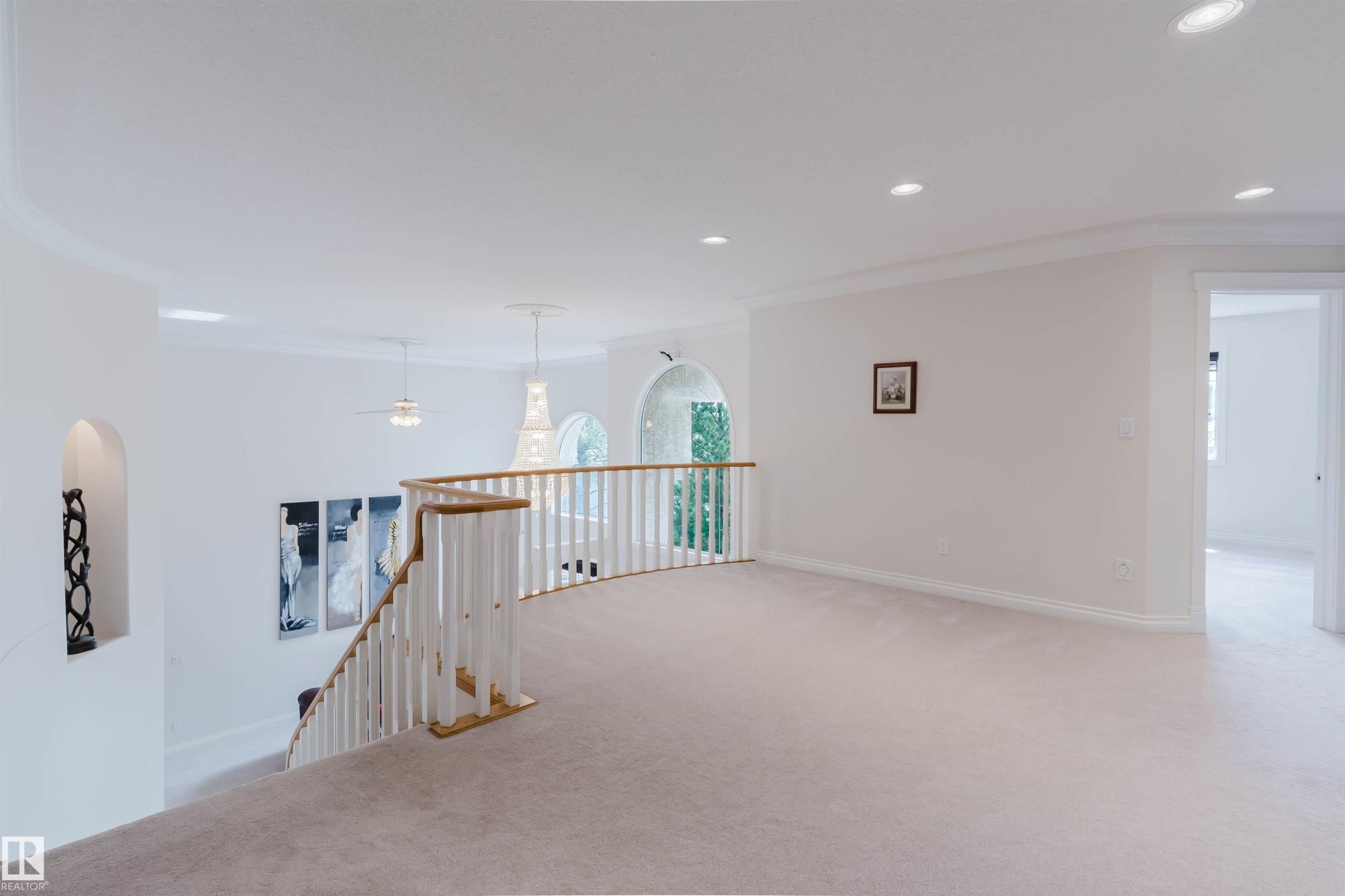 Spacious upper-level landing with light-colored carpeting, white baseboards, and crown molding - 928 Heacock Road Nw, Edmonton, AB - Indoor Photo Showing Other Room