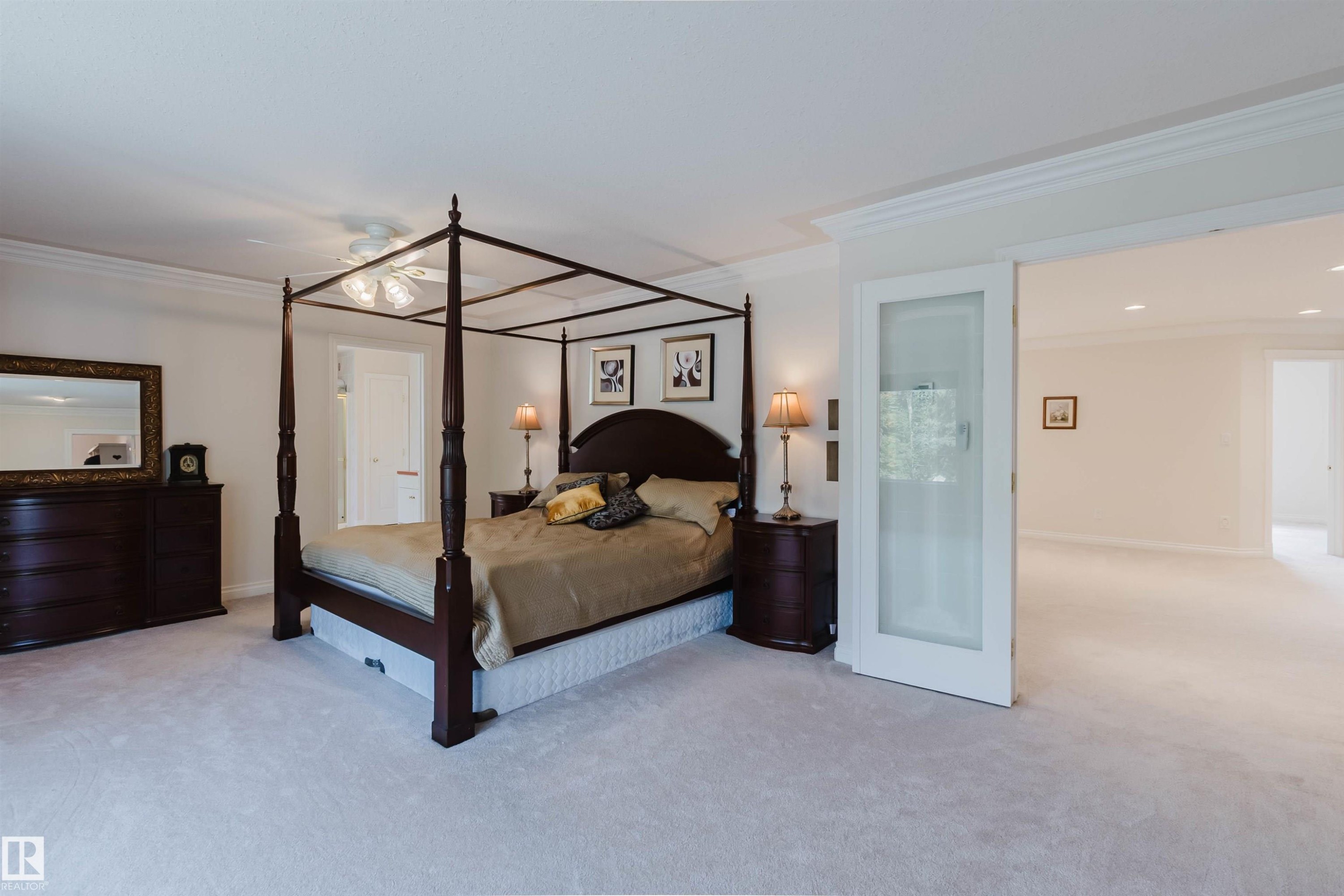 Spacious carpeted room featuring crown molding, a ceiling fan with light, and a white interior door - 928 Heacock Road Nw, Edmonton, AB - Indoor Photo Showing Bedroom