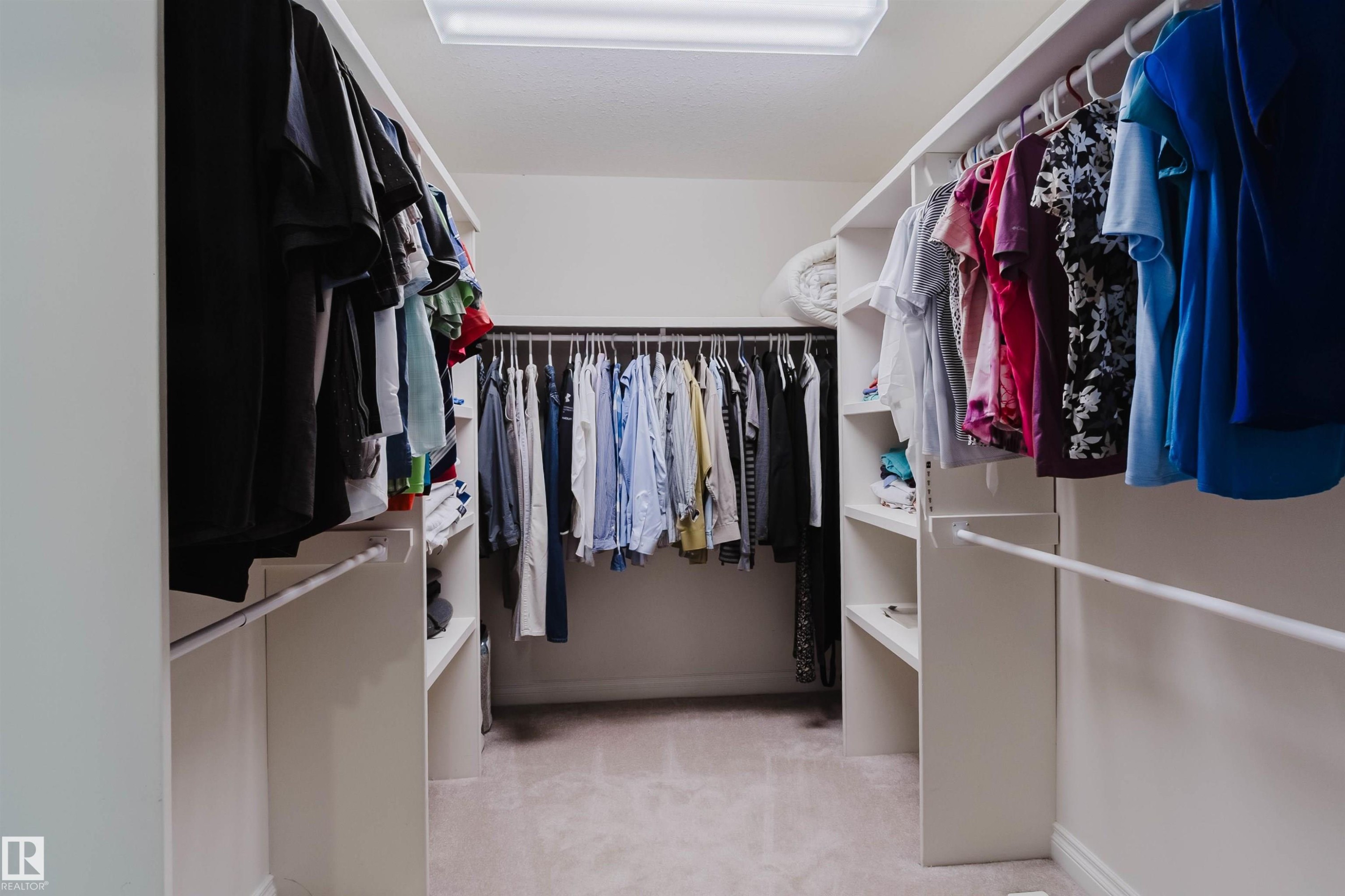 Walk-in closet featuring extensive built-in shelving, multiple hanging rods, and recessed lighting - 928 Heacock Road Nw, Edmonton, AB - Indoor With Storage