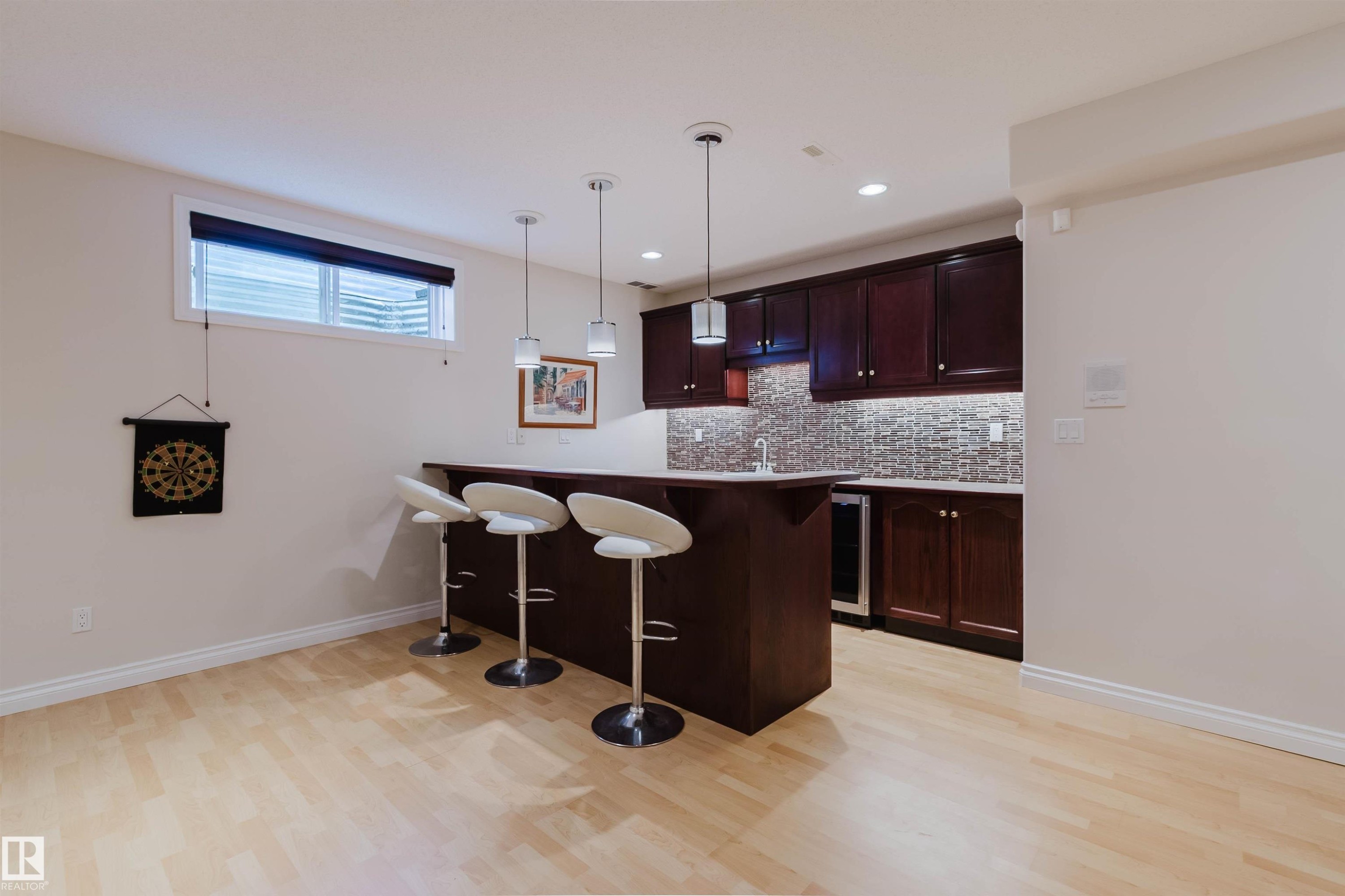 Integrated wet bar featuring a built-in beverage cooler, dark wood-finish cabinetry, and a mosaic tile backsplash - 928 Heacock Road Nw, Edmonton, AB - Indoor Photo Showing Kitchen