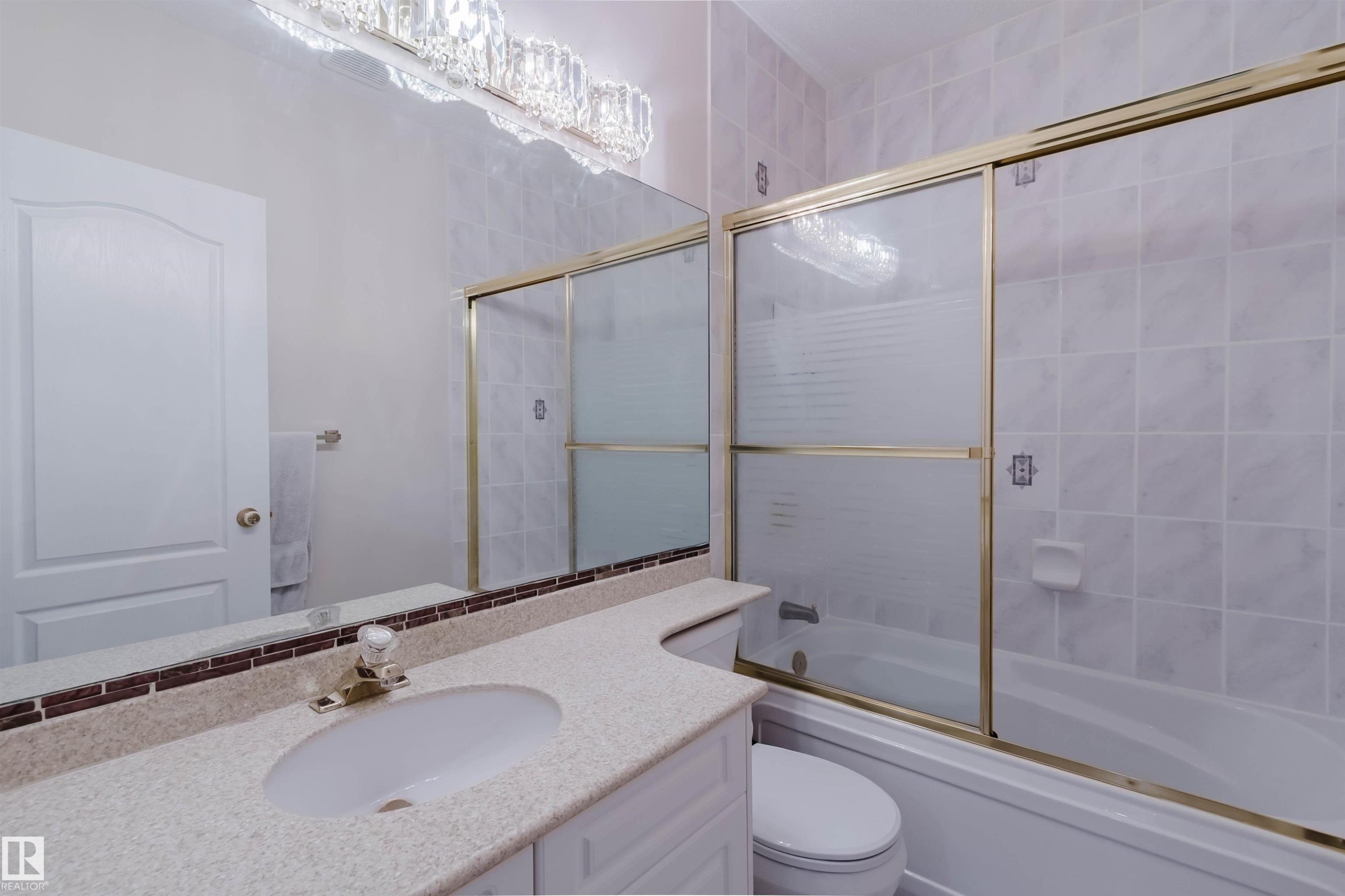 Bathroom vanity featuring a light-colored countertop, integrated sink, and an extensive mirror - 928 Heacock Road Nw, Edmonton, AB - Indoor Photo Showing Bathroom