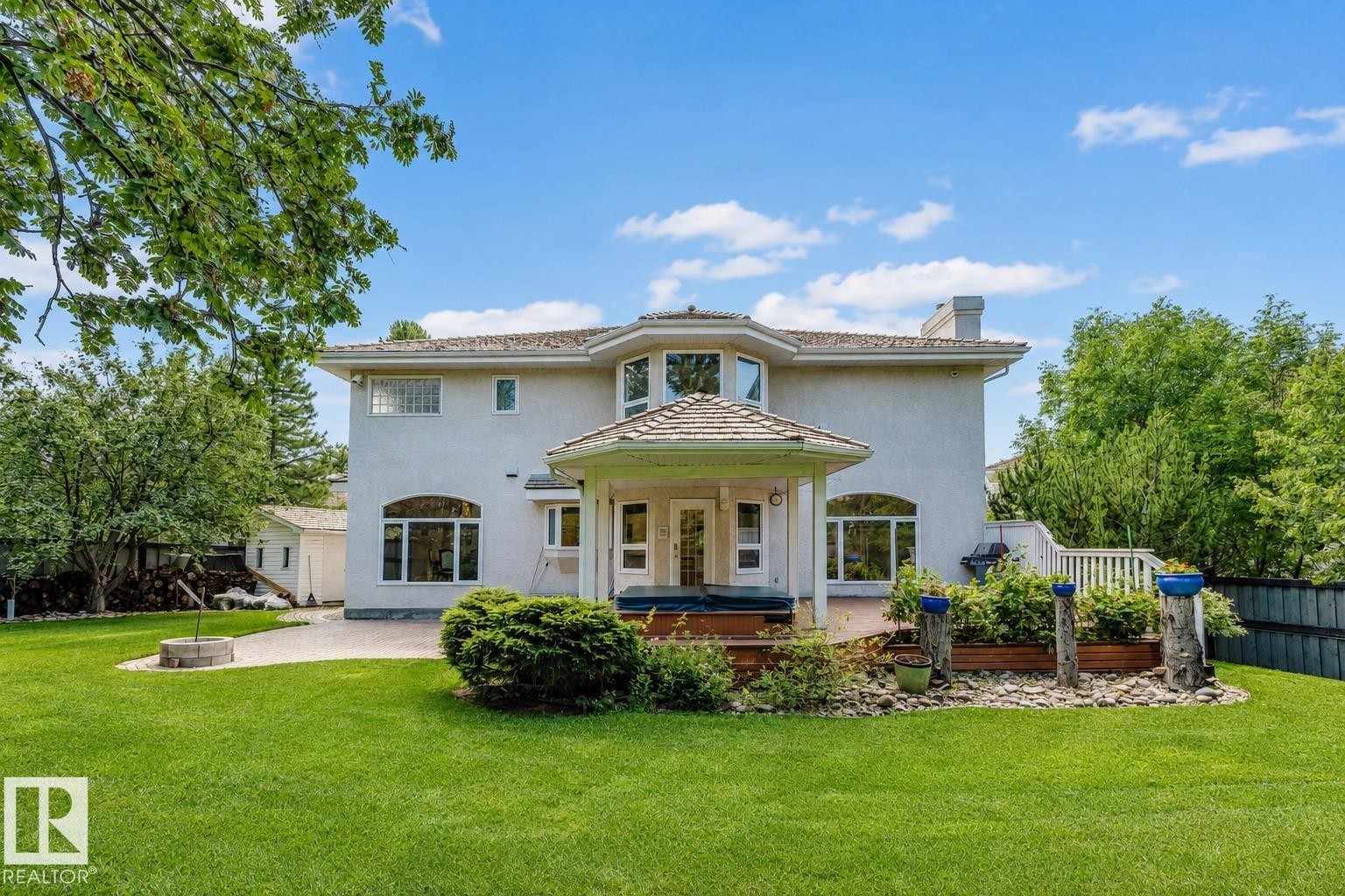 Stucco exterior with multiple large windows and a covered patio area - 928 Heacock Road Nw, Edmonton, AB - Outdoor