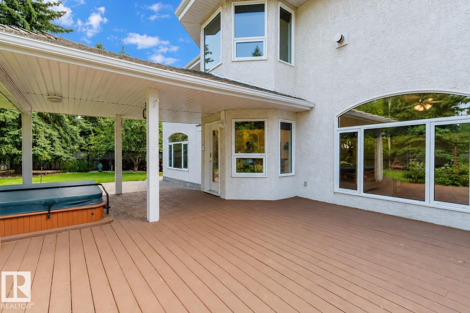 Expansive wood-finish deck featuring a covered patio area and a built-in spa - 928 Heacock Road Nw, Edmonton, AB - Outdoor With Deck Patio Veranda With Exterior