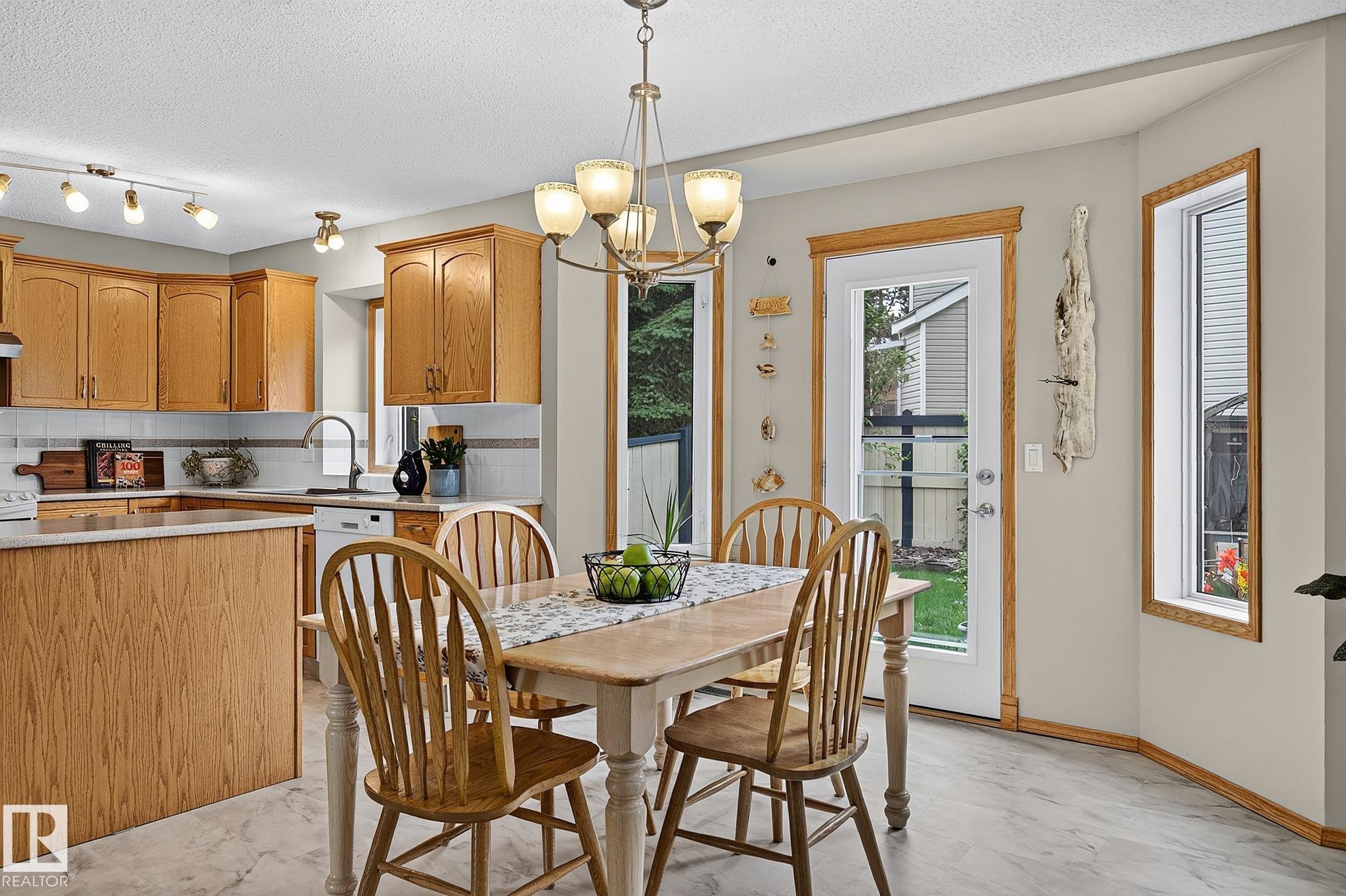 Dining area featuring a classic chandelier and light-coloured vinyl plank flooring - 385 Meadowview Terrace, Sherwood Park, AB - Indoor Photo Showing Dining Room