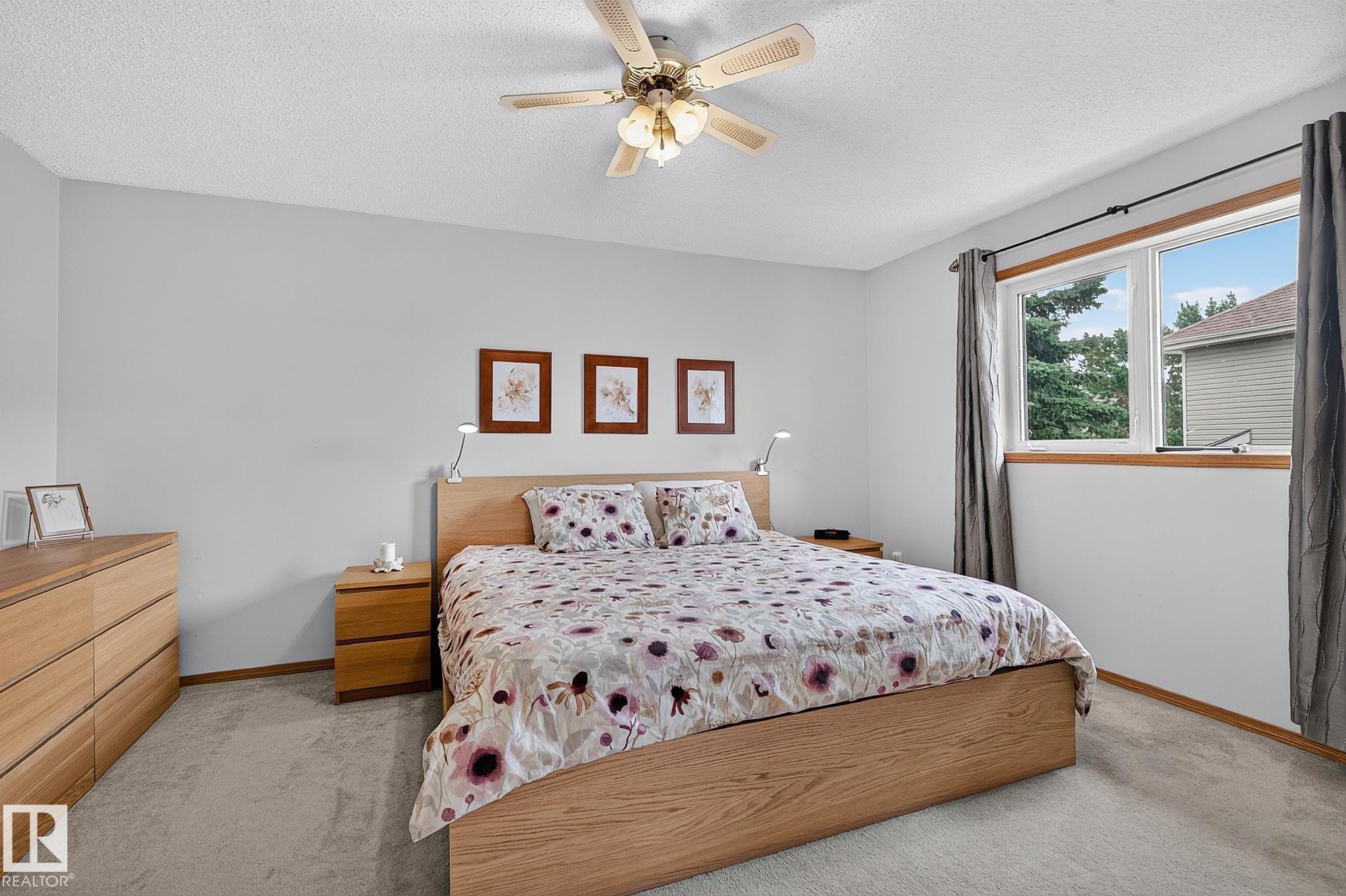 Primary bedroom featuring light wood-finish flooring, a ceiling fan with integrated lighting, and a window with wood trim - 385 Meadowview Terrace, Sherwood Park, AB - Indoor Photo Showing Bedroom