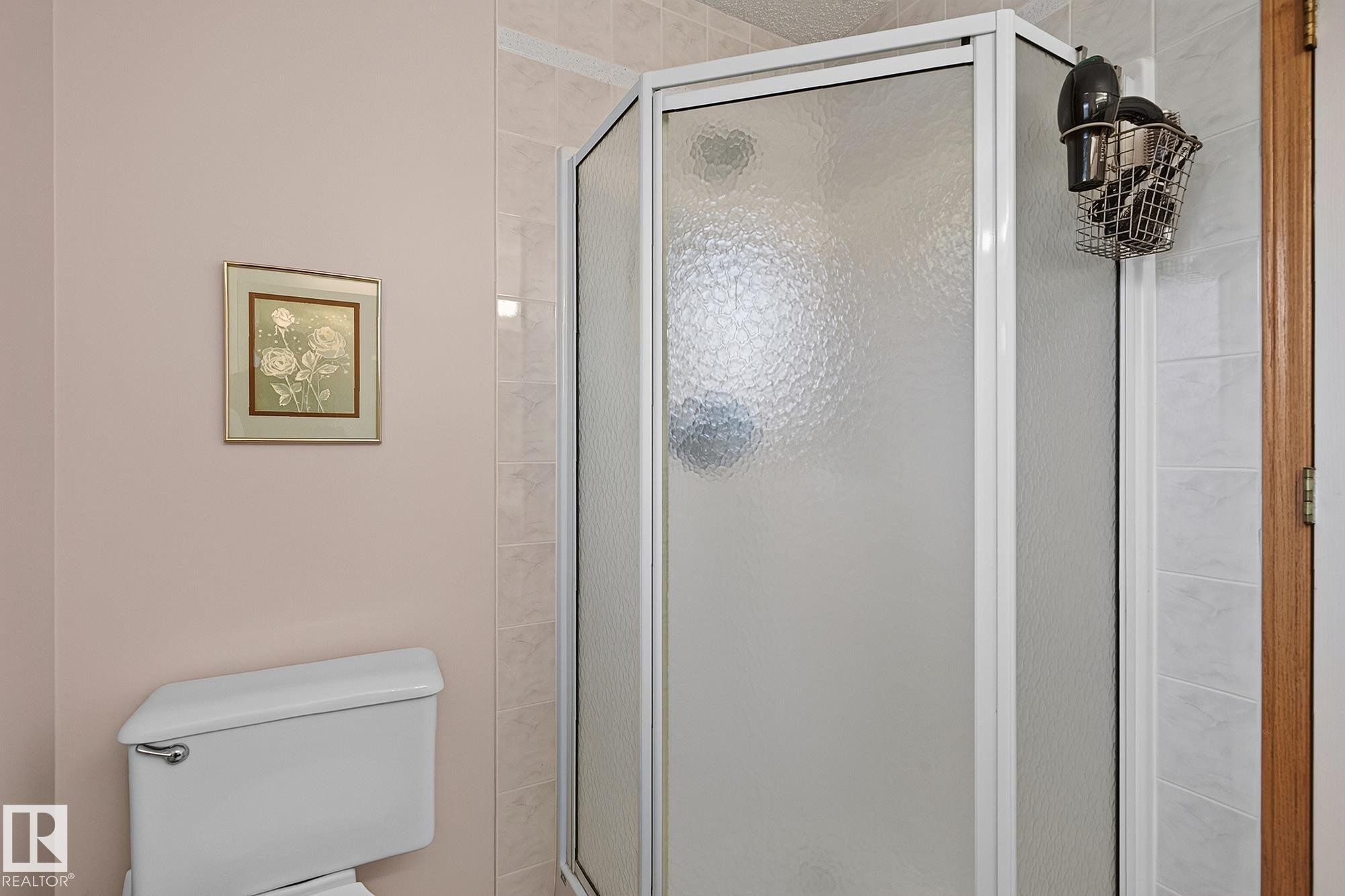 Enclosed shower in the ensuite bath with textured glass panels and white framing - 385 Meadowview Terrace, Sherwood Park, AB - Indoor Photo Showing Bathroom