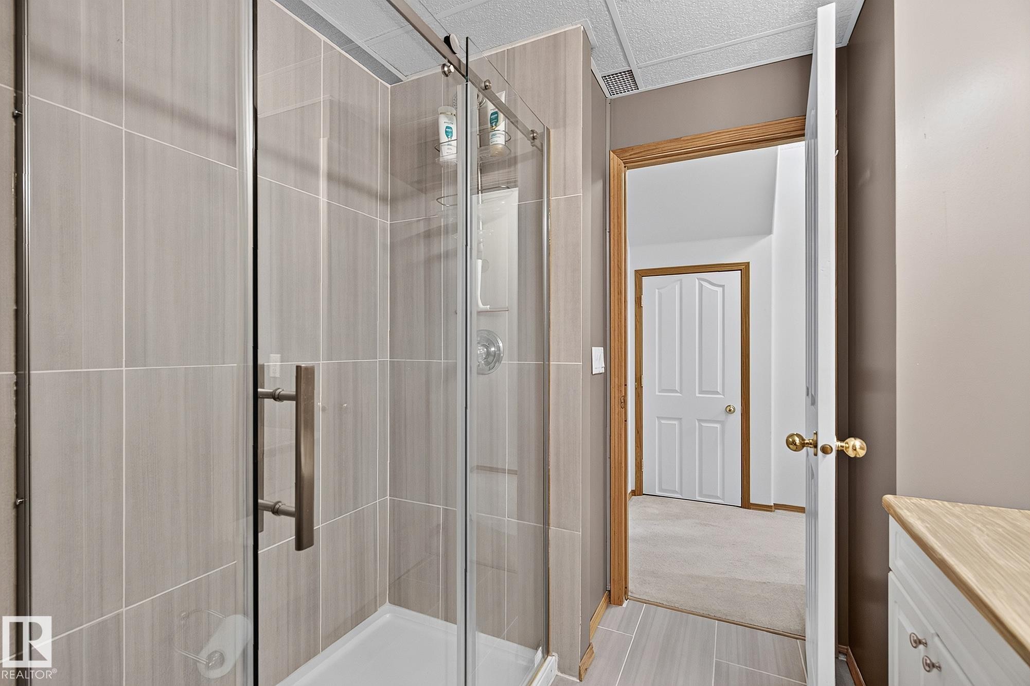 Basement bathroom has a shower enclosure with clear glass doors and brushed nickel hardware - 385 Meadowview Terrace, Sherwood Park, AB - Indoor Photo Showing Bathroom