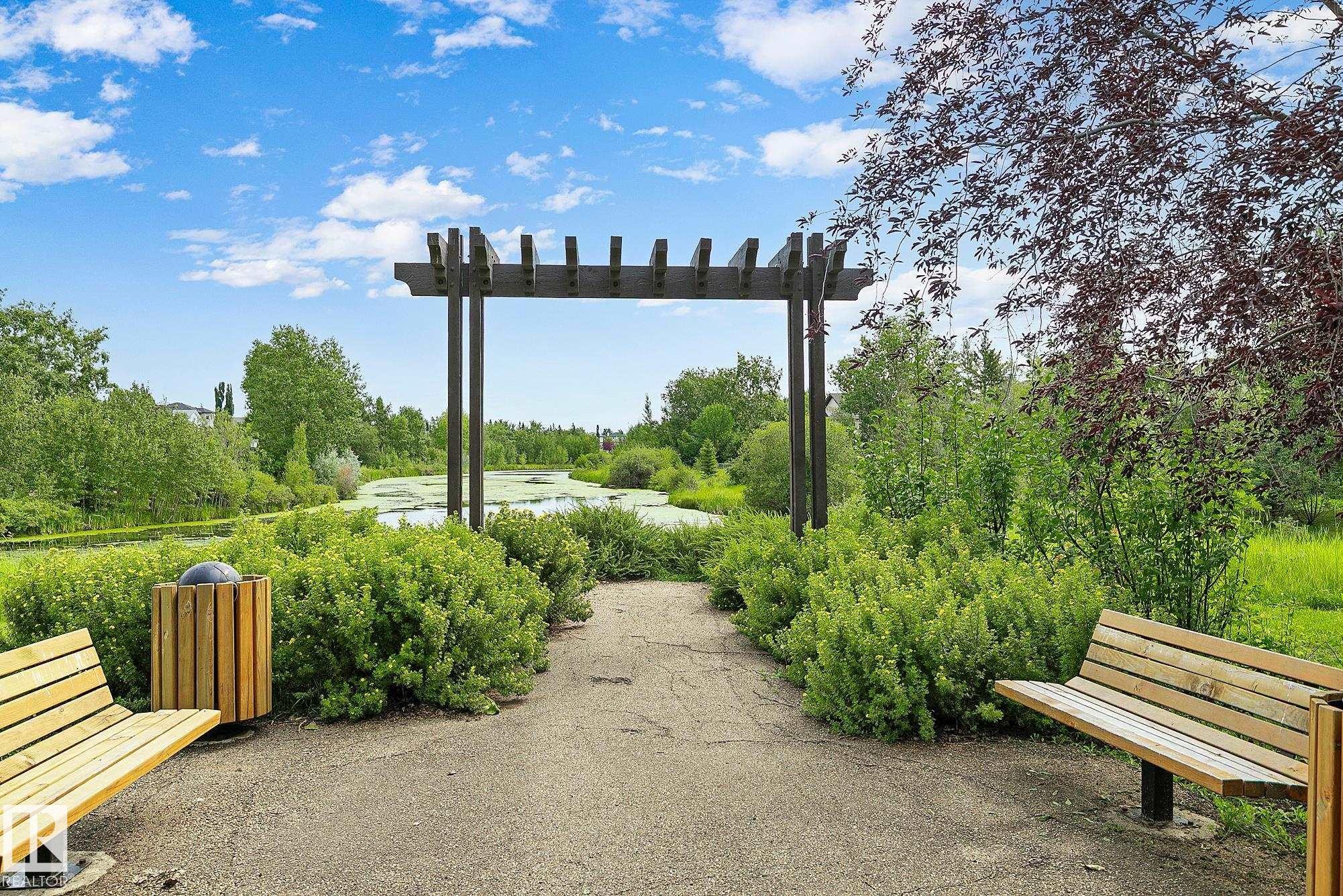 Landscaped path with a dark wood pergola, flanked by lush green bushes and mature trees - 385 Meadowview Terrace, Sherwood Park, AB - Outdoor