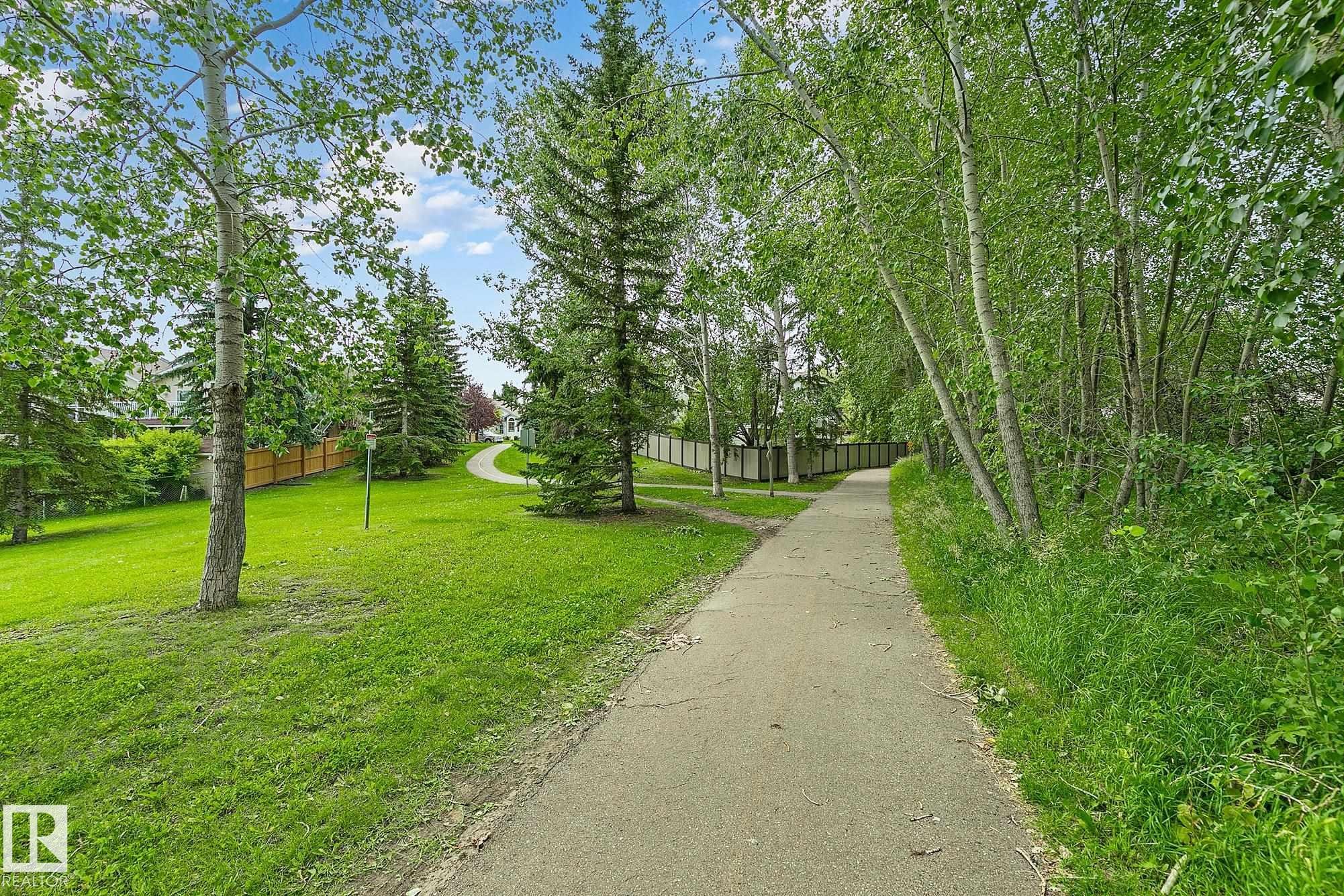 Paved pathway winding through mature trees and lush green lawns - 385 Meadowview Terrace, Sherwood Park, AB - Outdoor