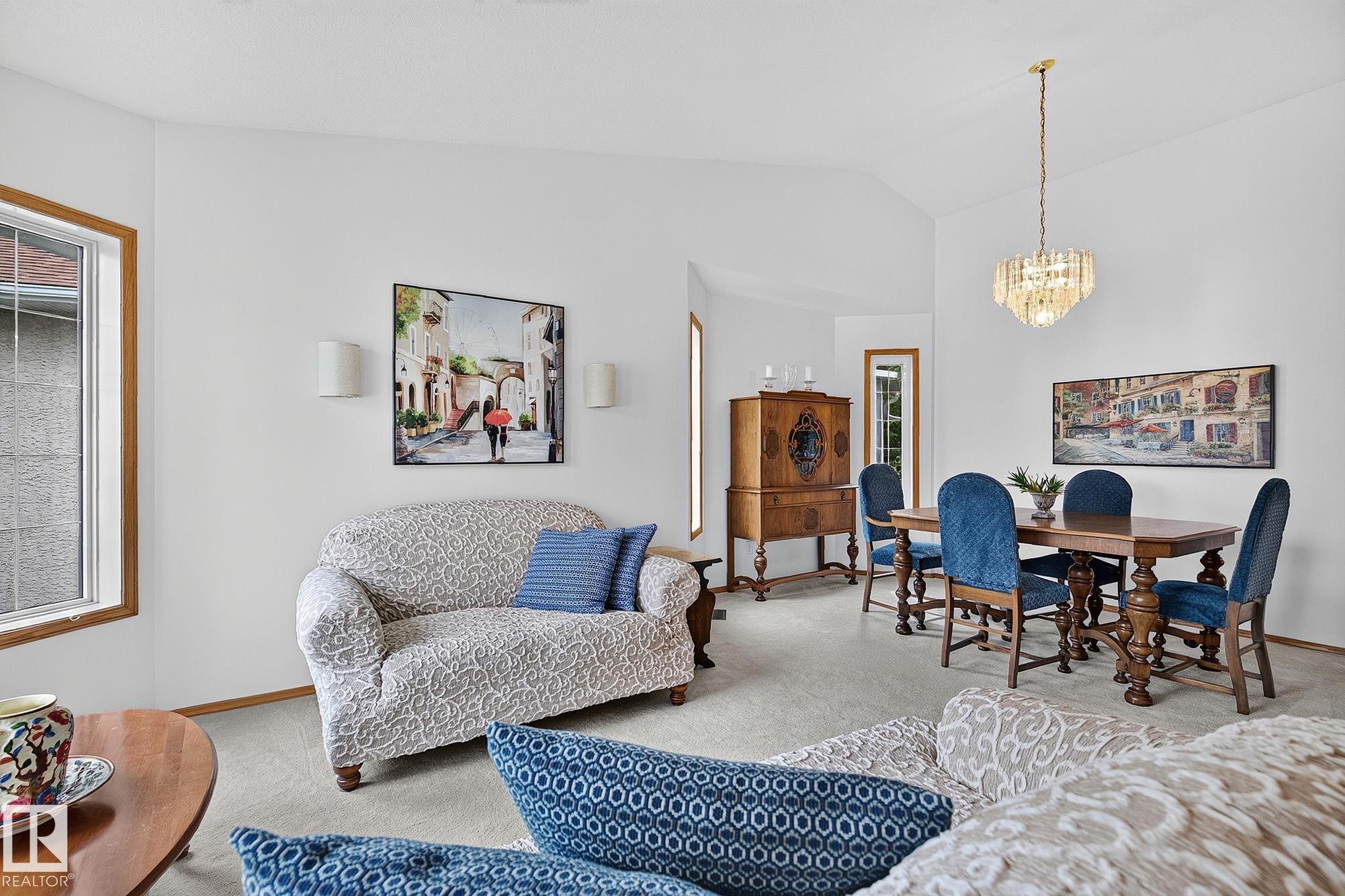 Vaulted ceilings enhance the living space, featuring a living room and dining area with a chandelier and carpeted floors - 385 Meadowview Terrace, Sherwood Park, AB - Indoor Photo Showing Living Room
