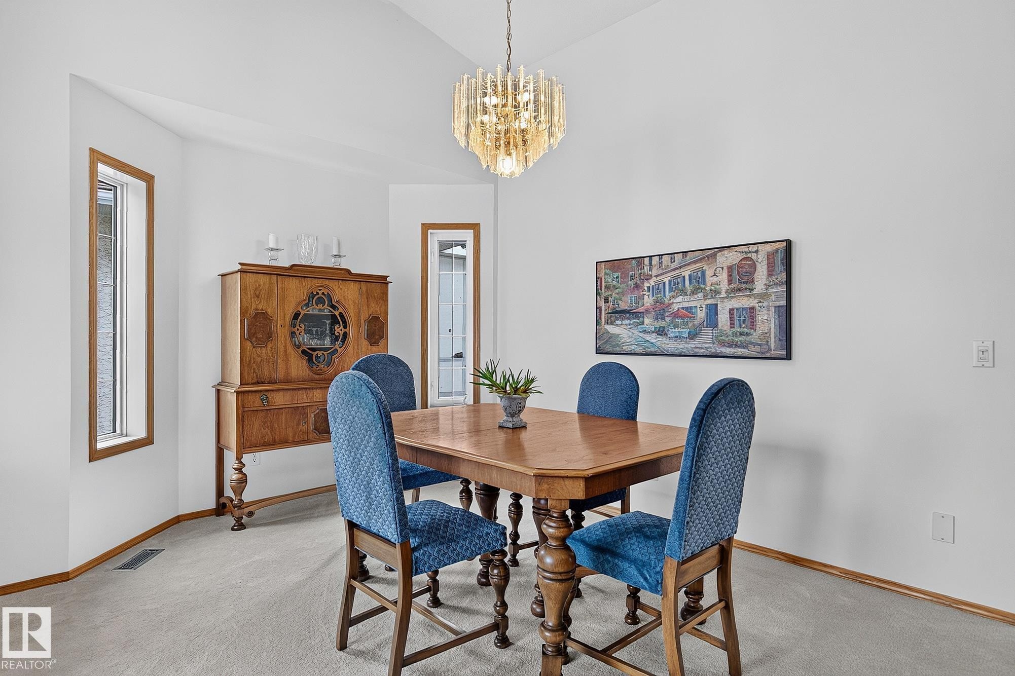 Dining area featuring a vaulted ceiling with a decorative chandelier, light-colored carpeting, and wood-trimmed windows - 385 Meadowview Terrace, Sherwood Park, AB - Indoor Photo Showing Dining Room