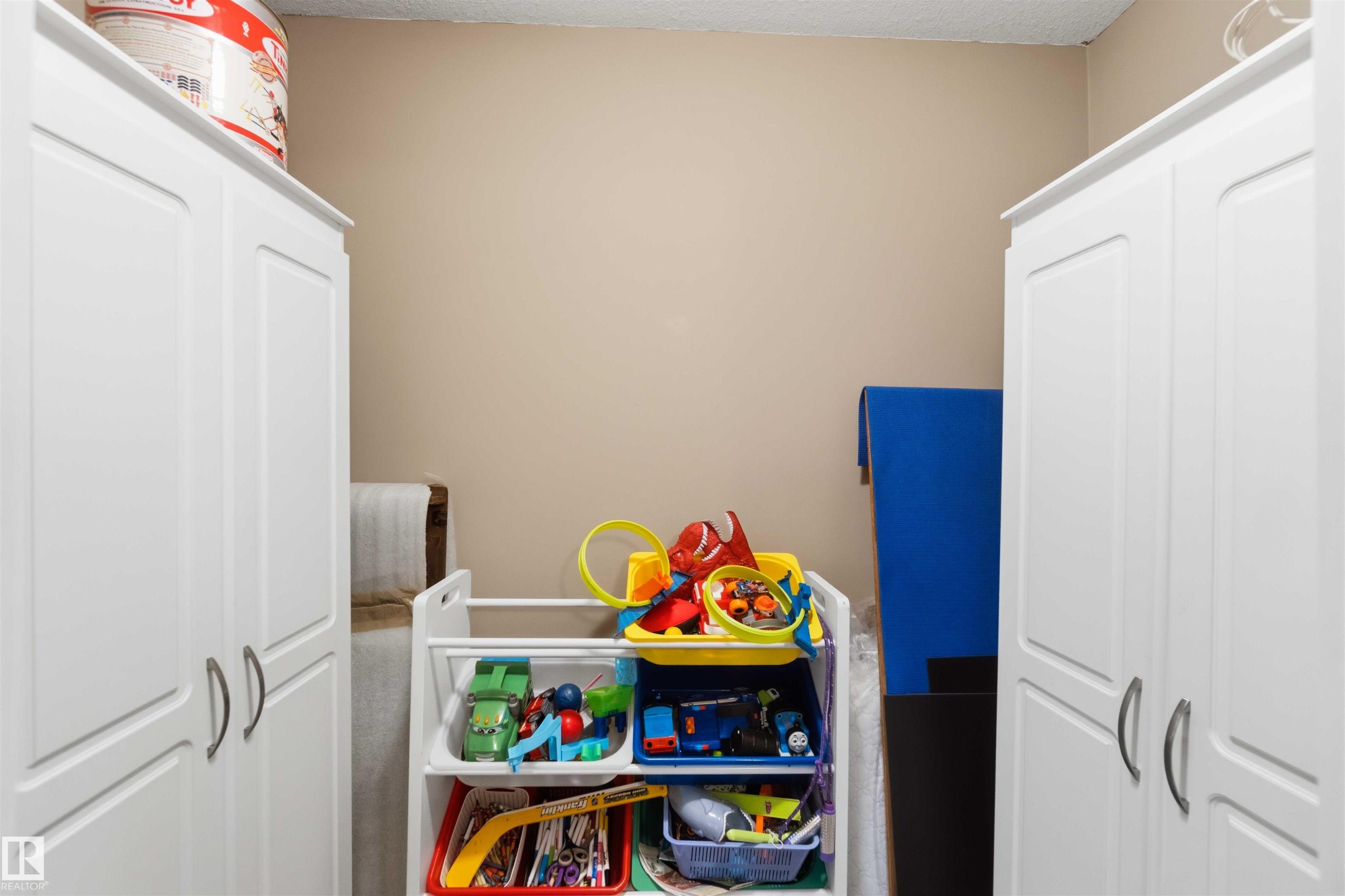 Two white storage cabinets with brushed nickel hardware flank a neutral-toned wall - 6320 166 Avenue Nw, Edmonton, AB - Indoor