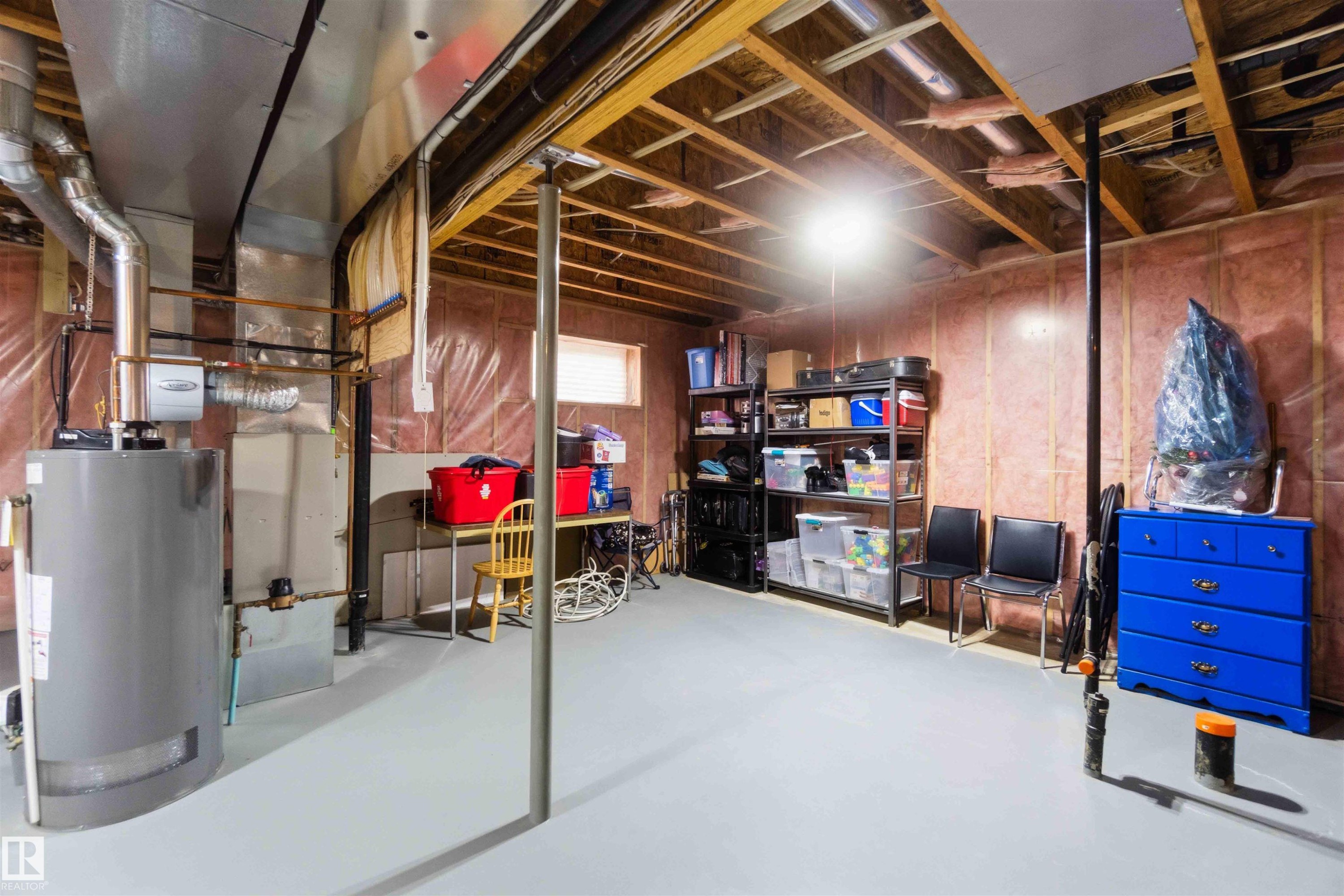 Unfinished basement offering exposed ceiling joists, insulated walls, concrete flooring, a water heater, and a furnace unit - 6320 166 Avenue Nw, Edmonton, AB - Indoor Photo Showing Basement