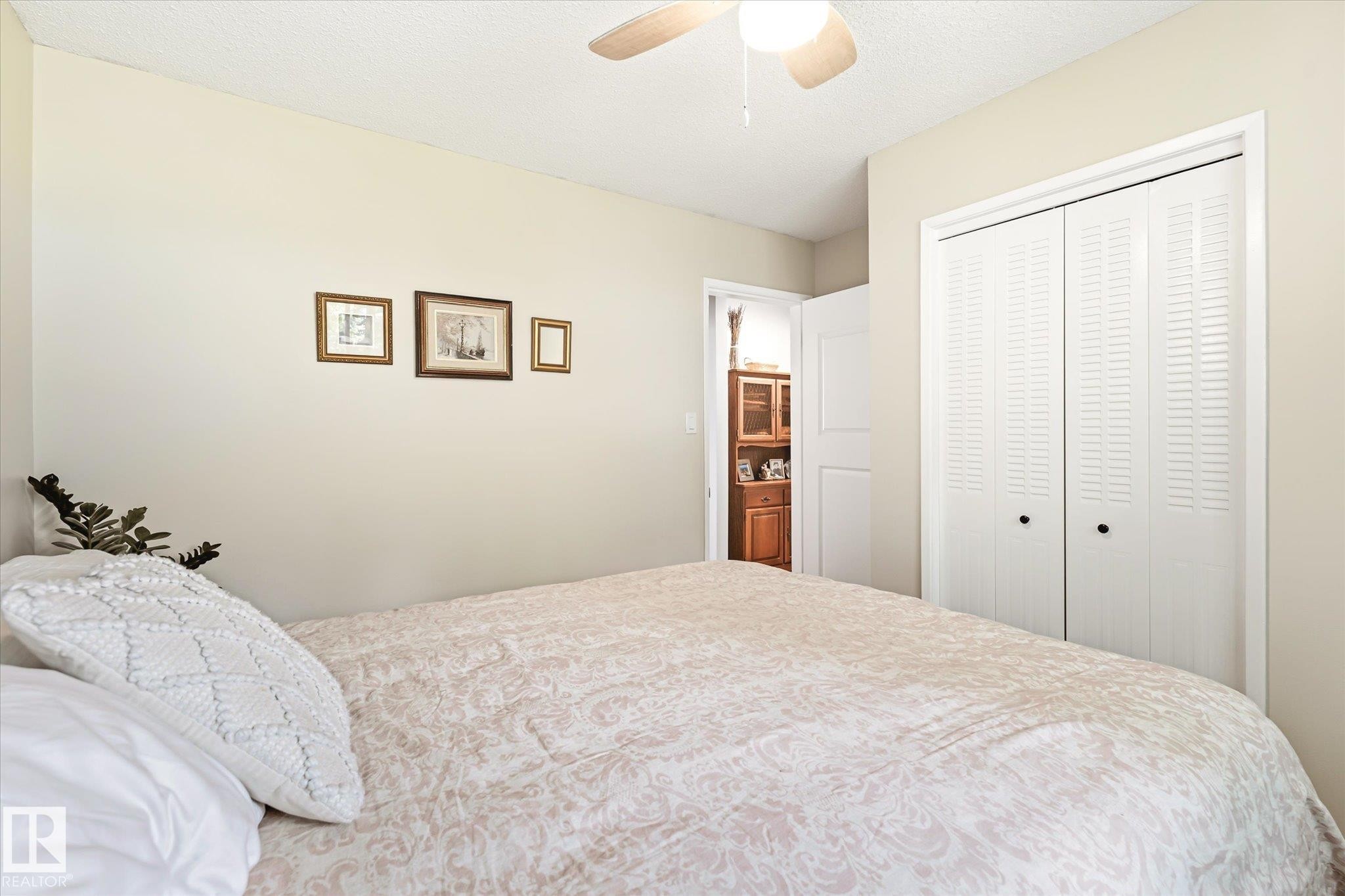 Room featuring neutral wall tones, a ceiling fan with integrated lighting, and white louvered bifold closet doors - 4921 47 Avenue, Legal, AB - Indoor Photo Showing Bedroom