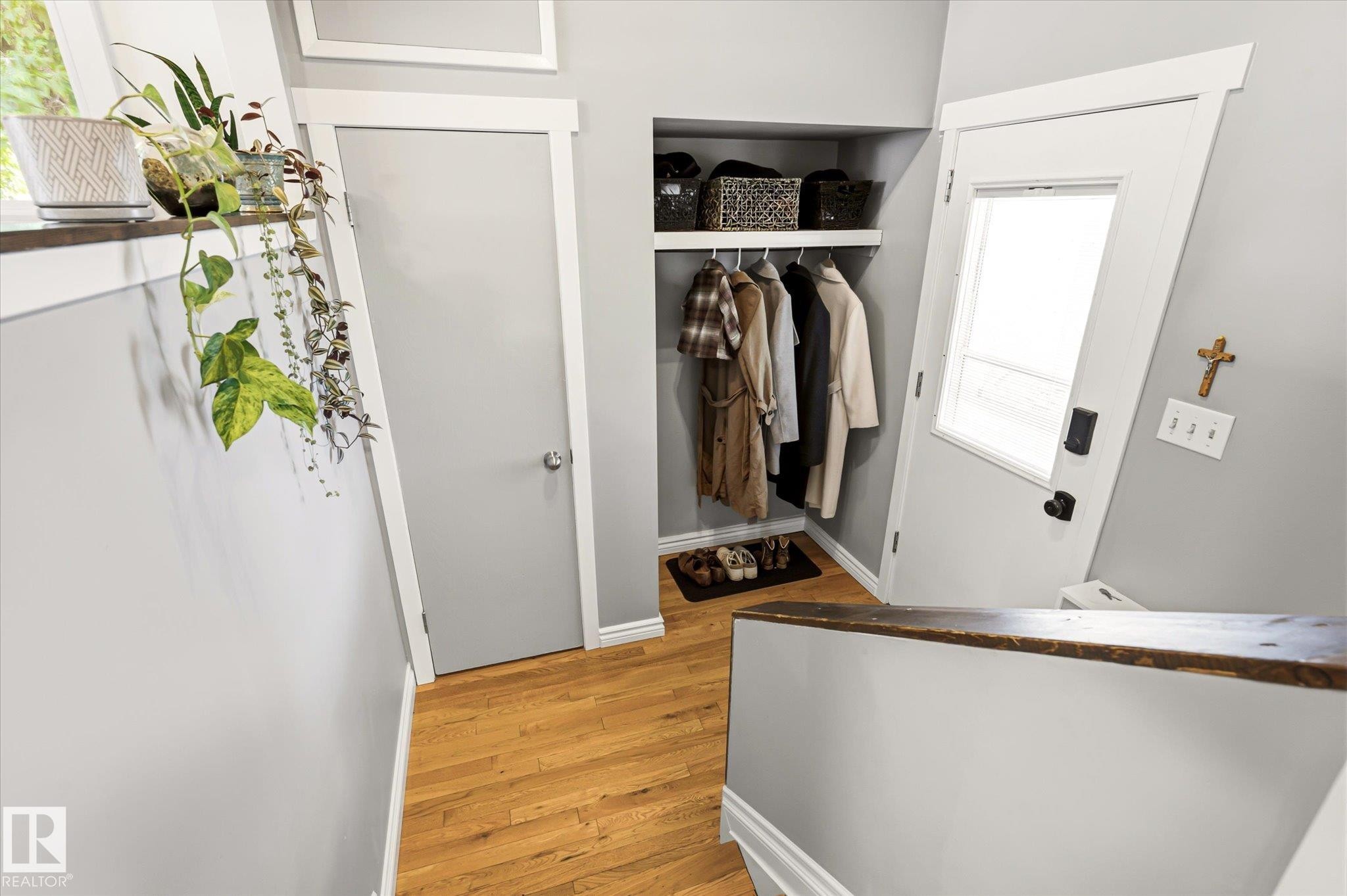 Entryway featuring wood-finish flooring, a built-in coat nook with shelving, a white paneled door with glass insert, and light gray wall paint - 4921 47 Avenue, Legal, AB - Indoor