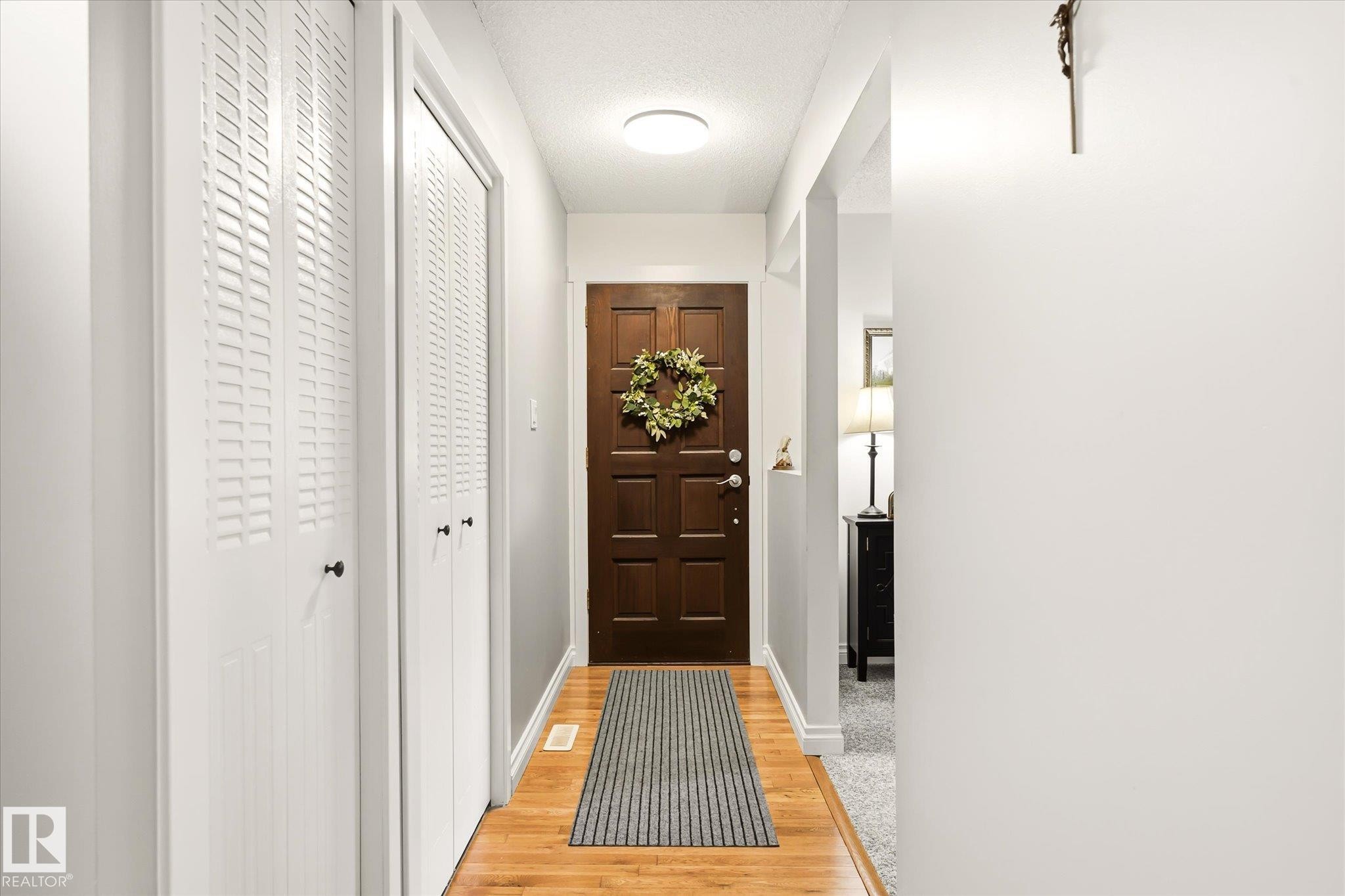 Entryway featuring wood-finish flooring, a paneled front door, white louvered bifold closet doors, and recessed ceiling lighting - 4921 47 Avenue, Legal, AB - Indoor Photo Showing Other Room