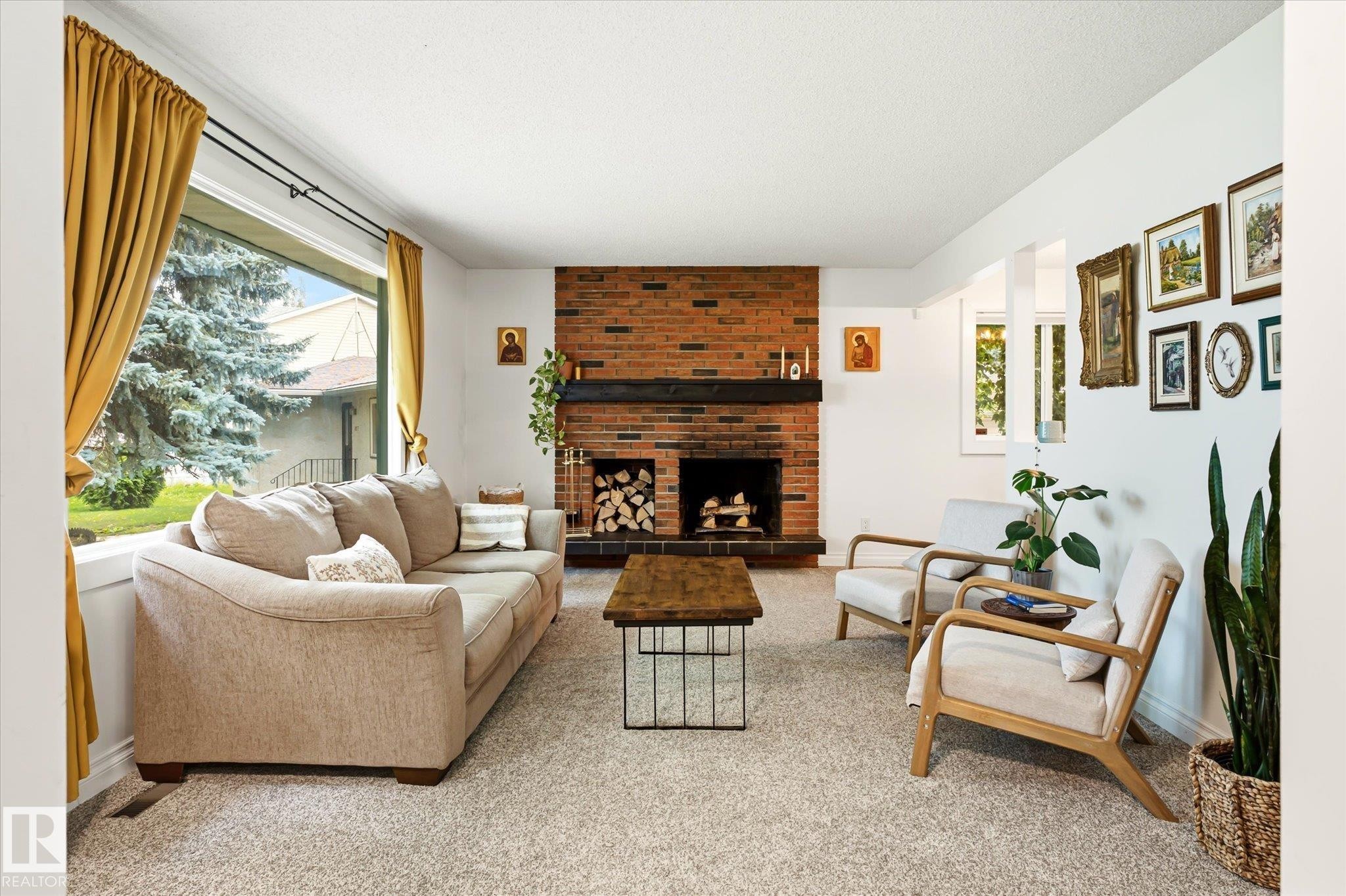 Living area featuring a brick fireplace with a dark wood mantel, large picture windows, recessed lighting, and light-toned carpet flooring - 4921 47 Avenue, Legal, AB - Indoor Photo Showing Living Room With Fireplace