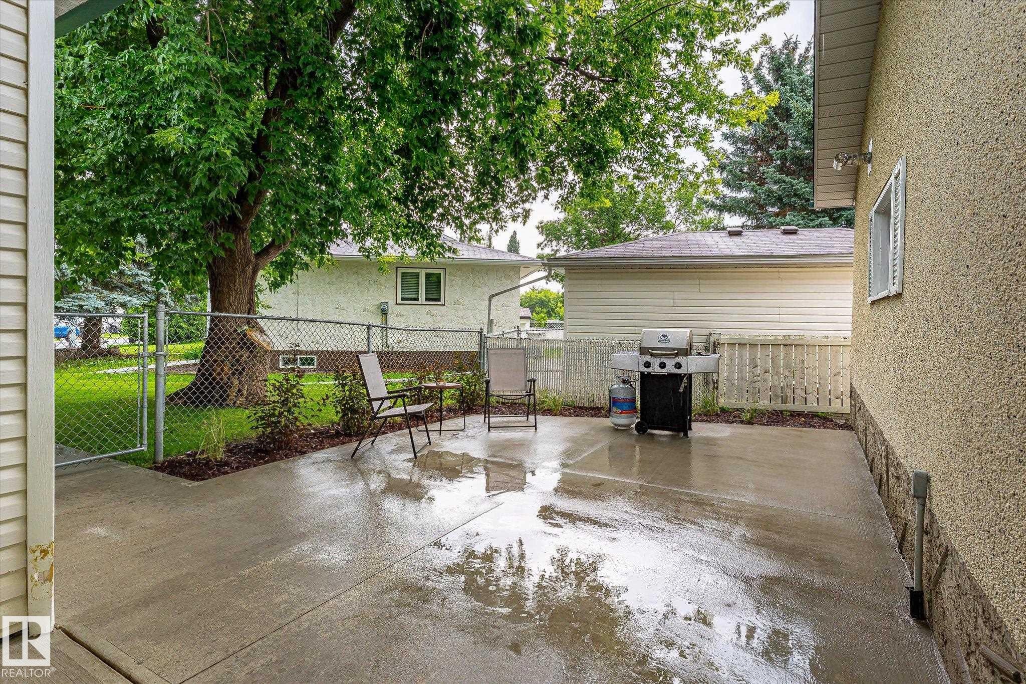 Concrete patio with an adjacent chain-link fence and gate - 4921 47 Avenue, Legal, AB - Outdoor