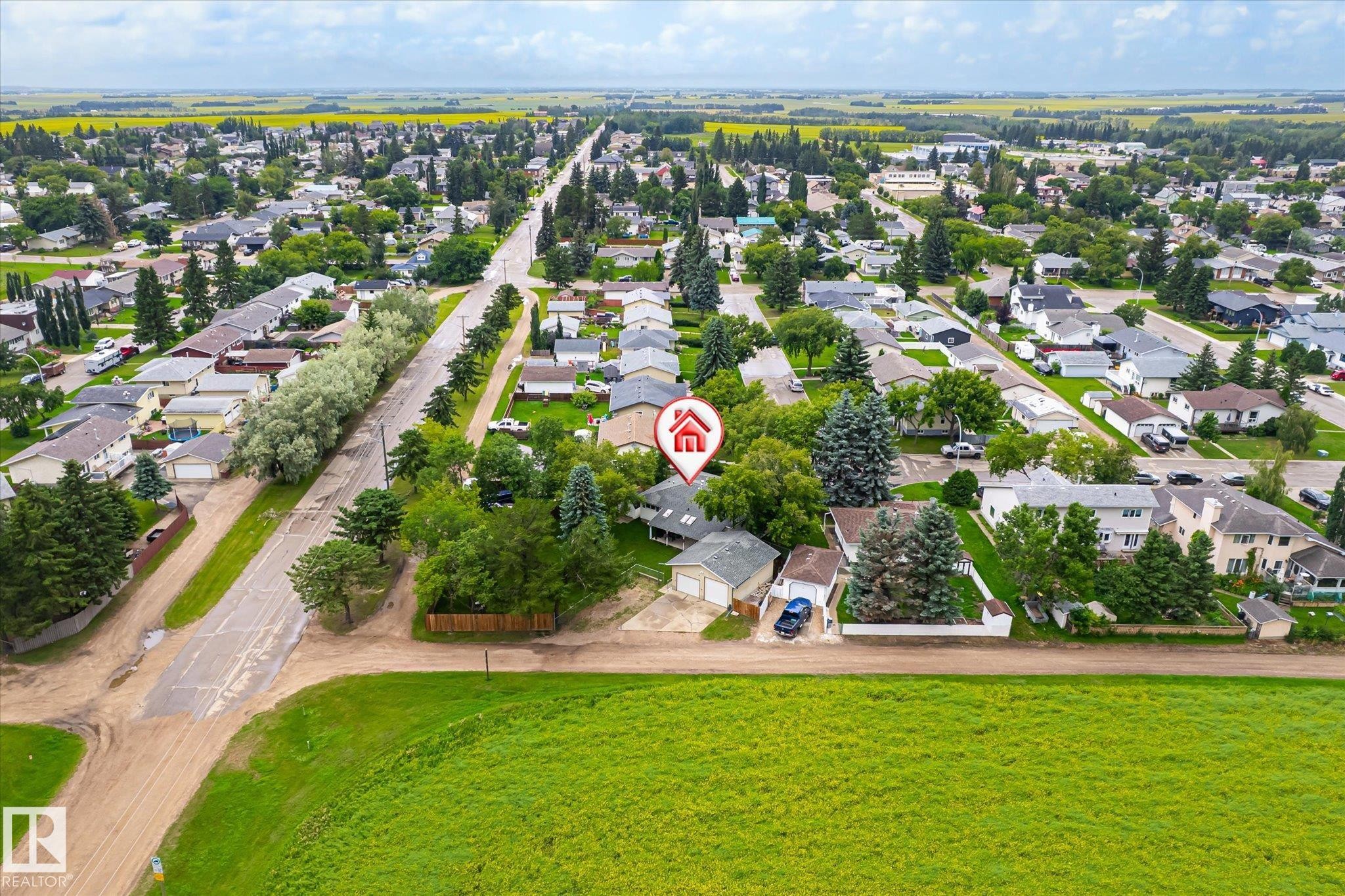 Aerial view showcasing a residential area bordered by open green fields and agricultural land - 4921 47 Avenue, Legal, AB - Outdoor With View