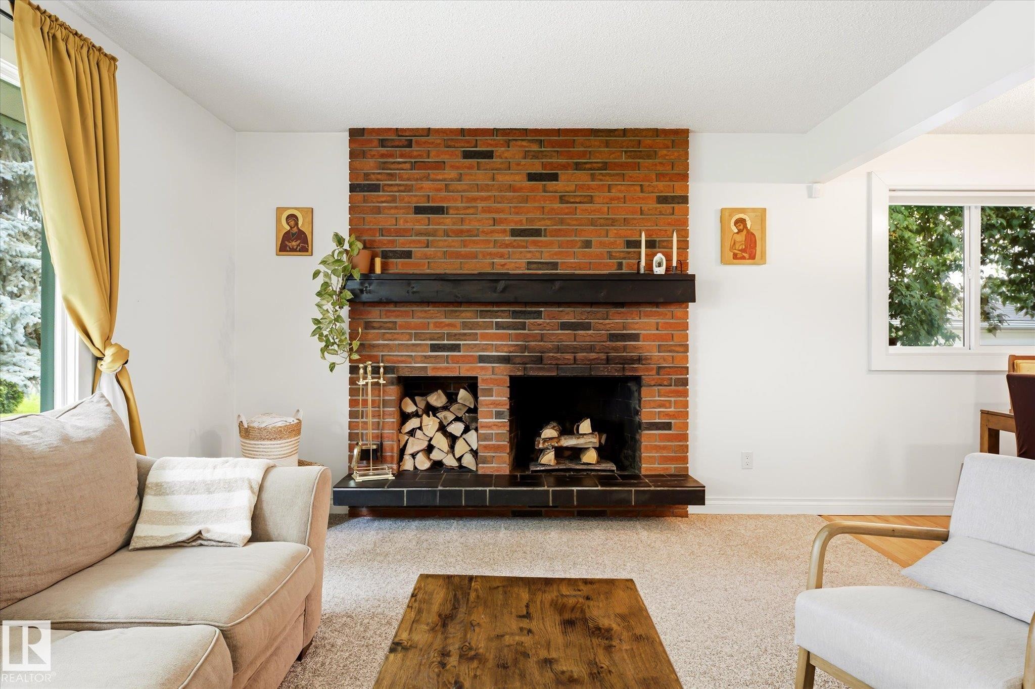 Brick fireplace with a dark wood mantel and hearth - 4921 47 Avenue, Legal, AB - Indoor Photo Showing Living Room With Fireplace