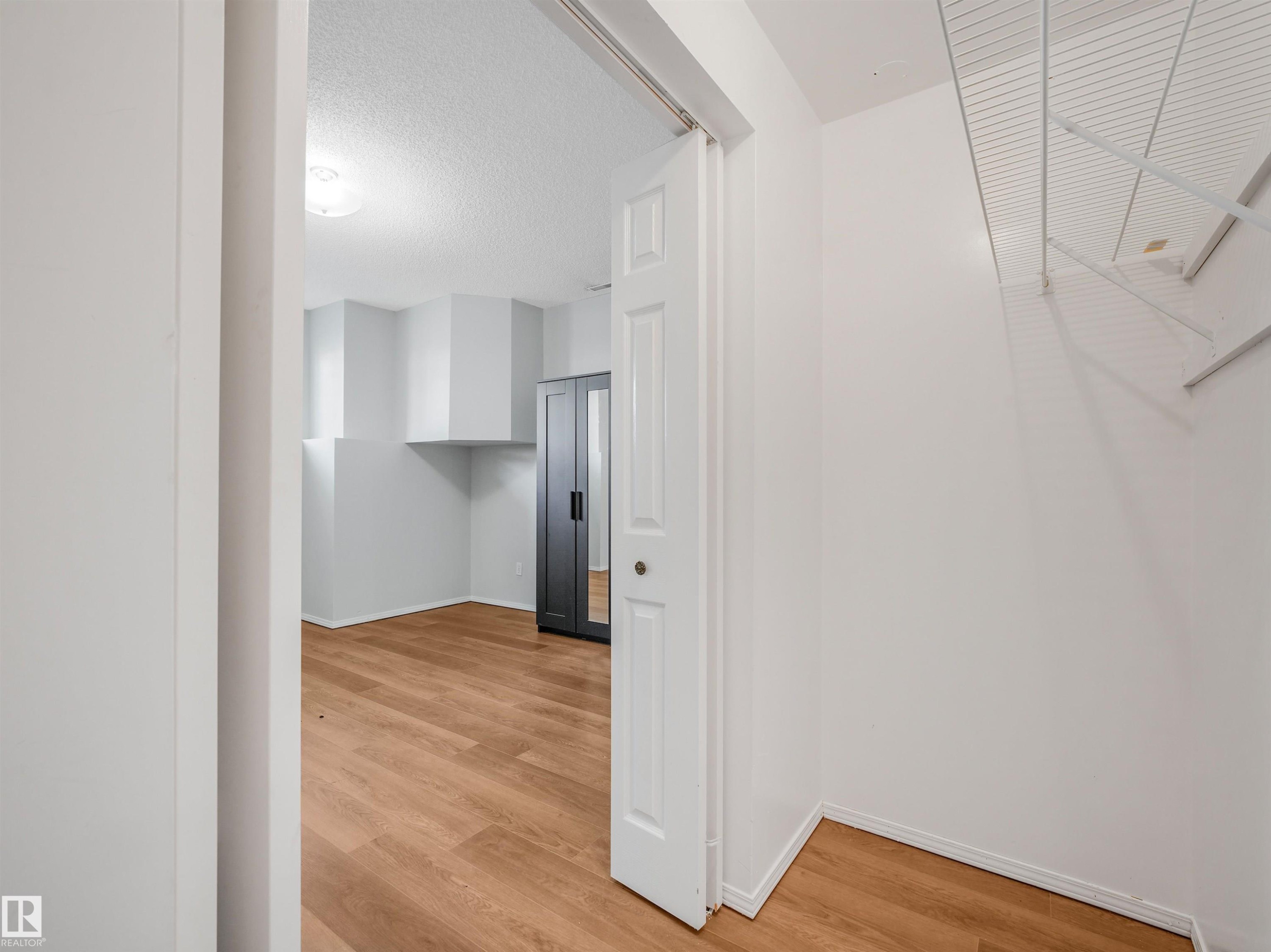 Interior space featuring wood-finish flooring, white walls, and a recessed ceiling light fixture - #2 3311 58 St Nw, Edmonton, AB - Indoor