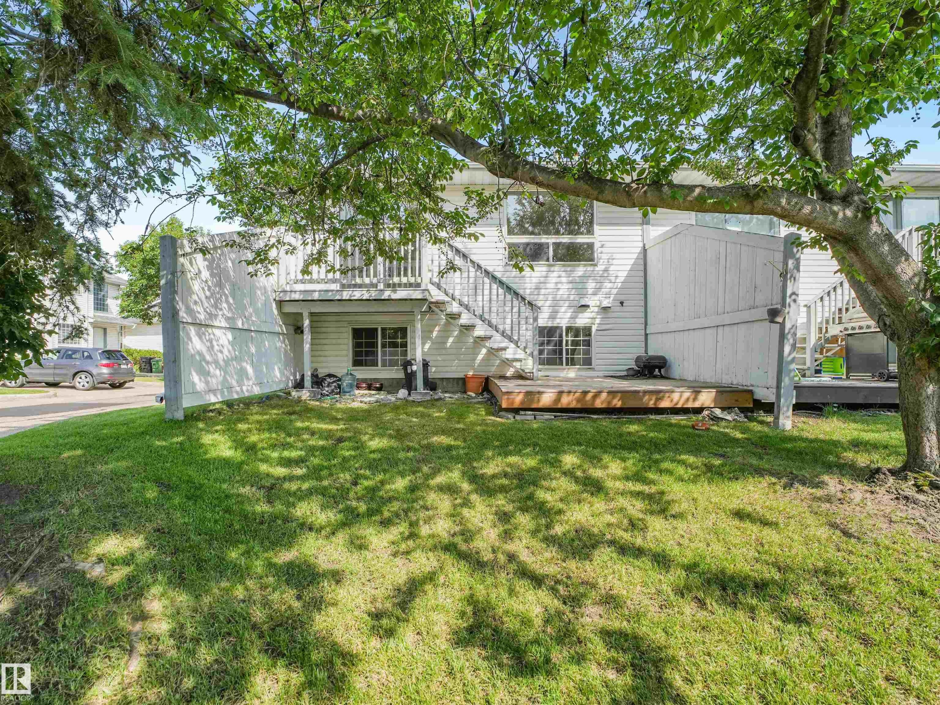 Expansive green lawn with mature tree providing shade - #2 3311 58 St Nw, Edmonton, AB - Outdoor