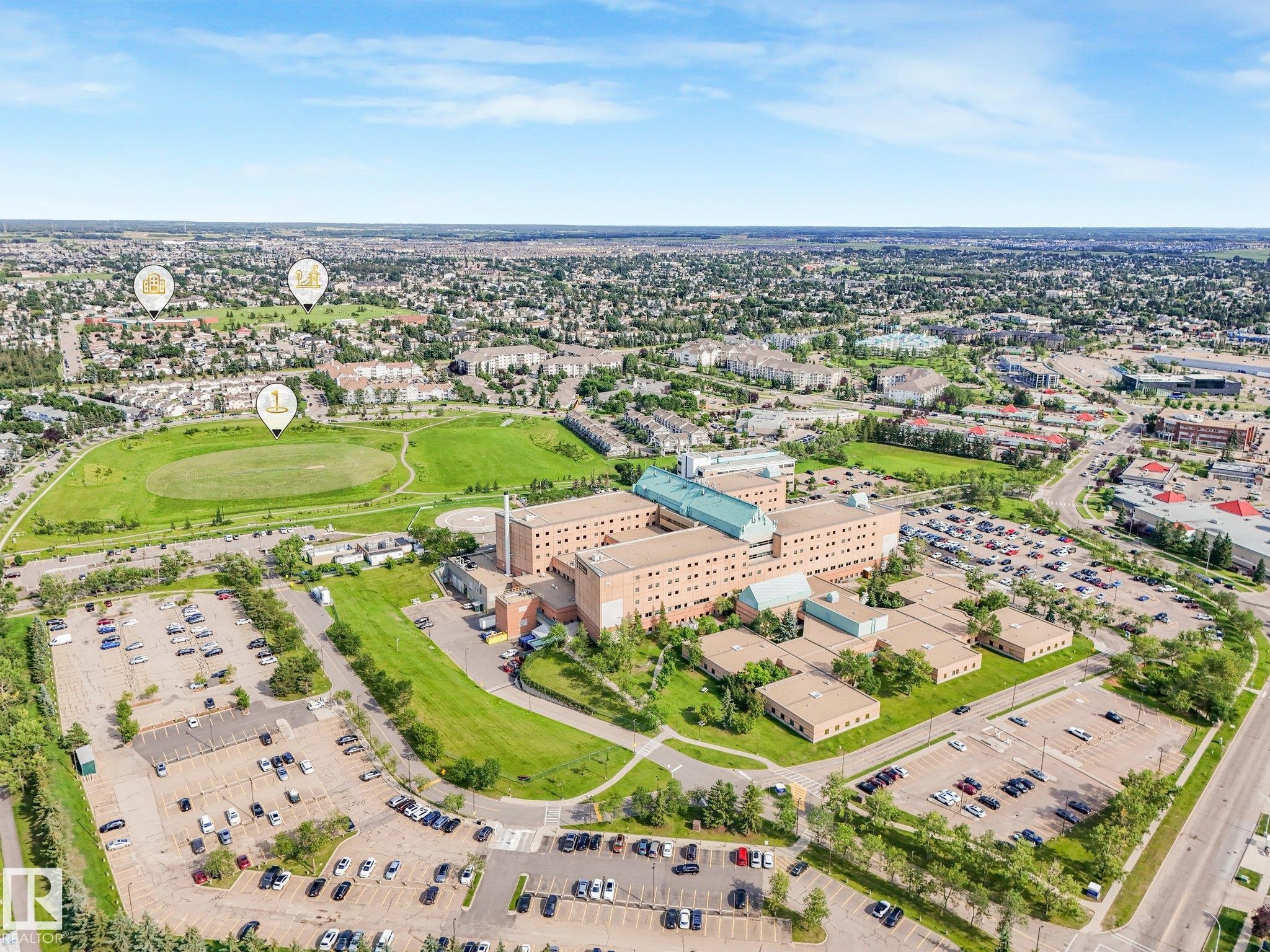 Aerial perspective showcasing a large-scale institutional building with extensive parking facilities - #2 3311 58 St Nw, Edmonton, AB - Outdoor With View