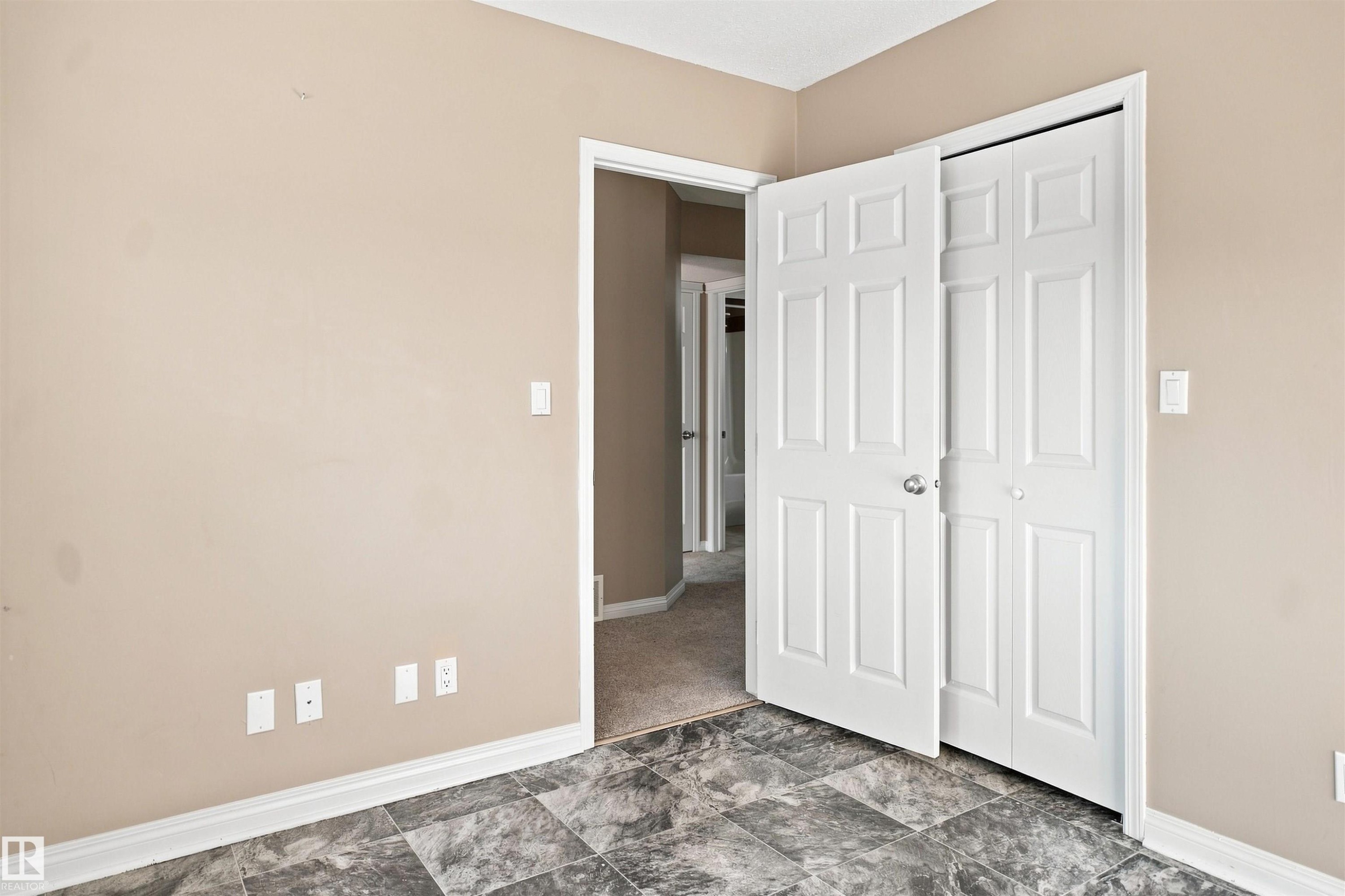 Room featuring grey patterned flooring, neutral wall tones, and white trim - 1328 80 Street Sw, Edmonton, AB - Indoor Photo Showing Other Room