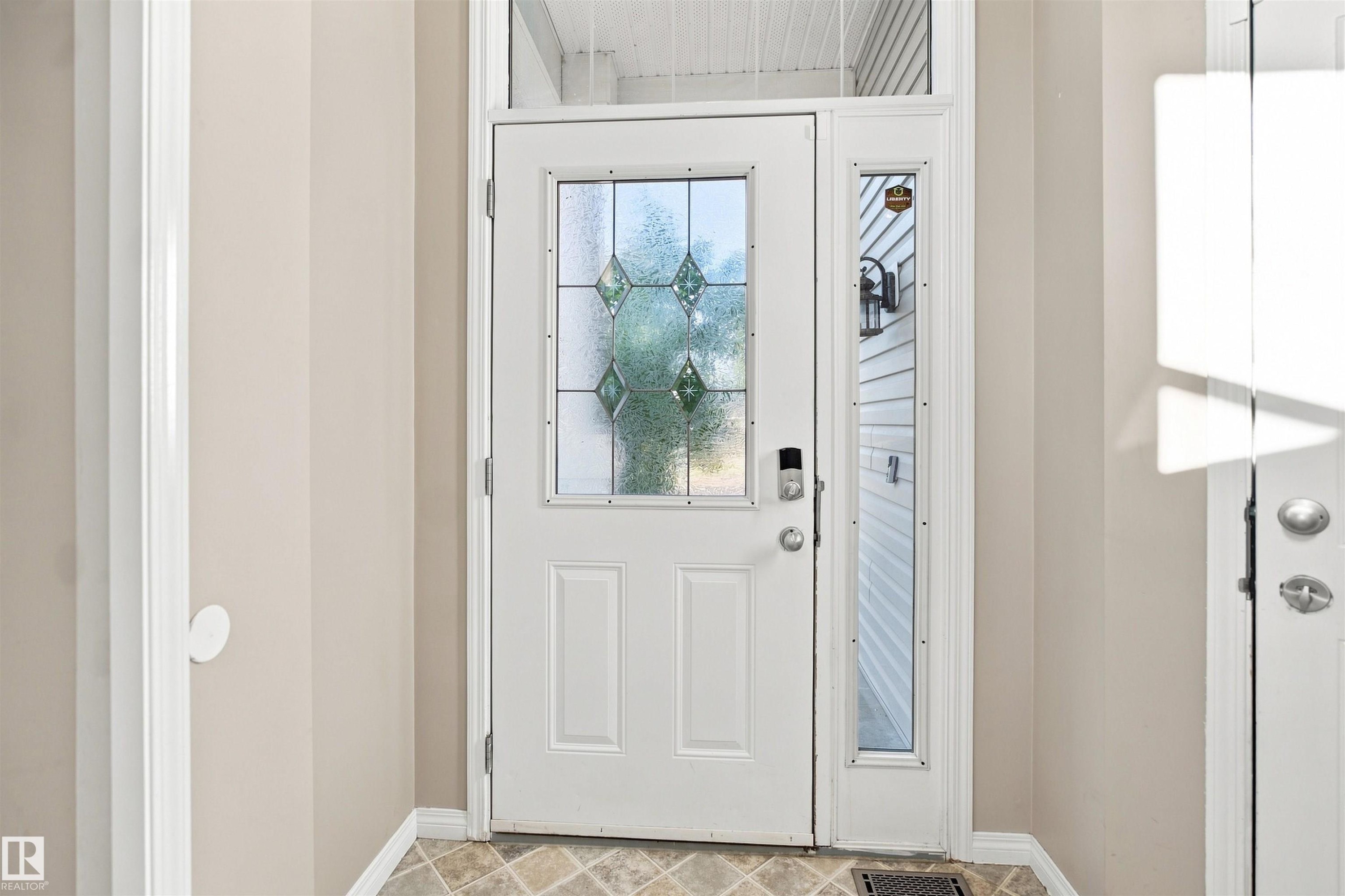 Entryway featuring a white door with decorative glass inserts, a coordinating sidelight, and a transom window - 1328 80 Street Sw, Edmonton, AB - Indoor Photo Showing Other Room