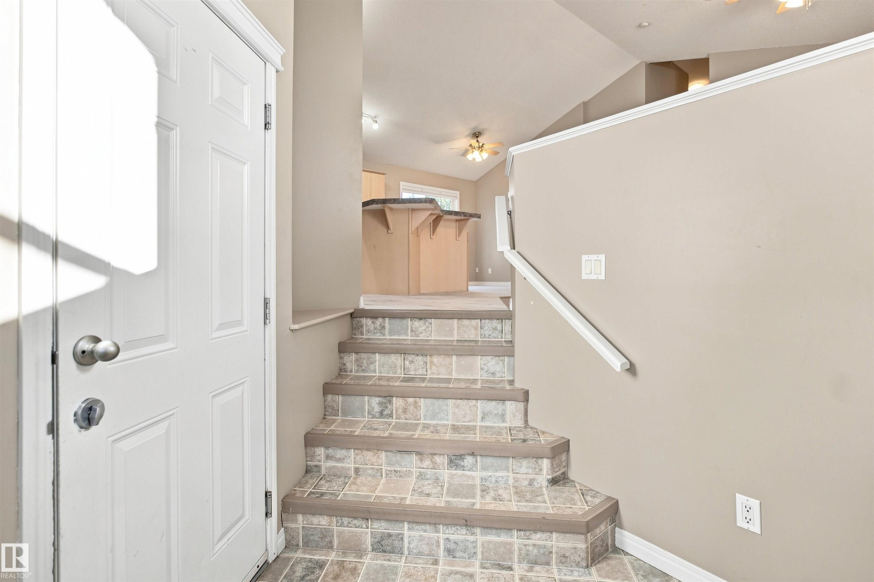 Entryway featuring tile-finish stairs and neutral wall tones - 1328 80 Street Sw, Edmonton, AB - Indoor Photo Showing Other Room