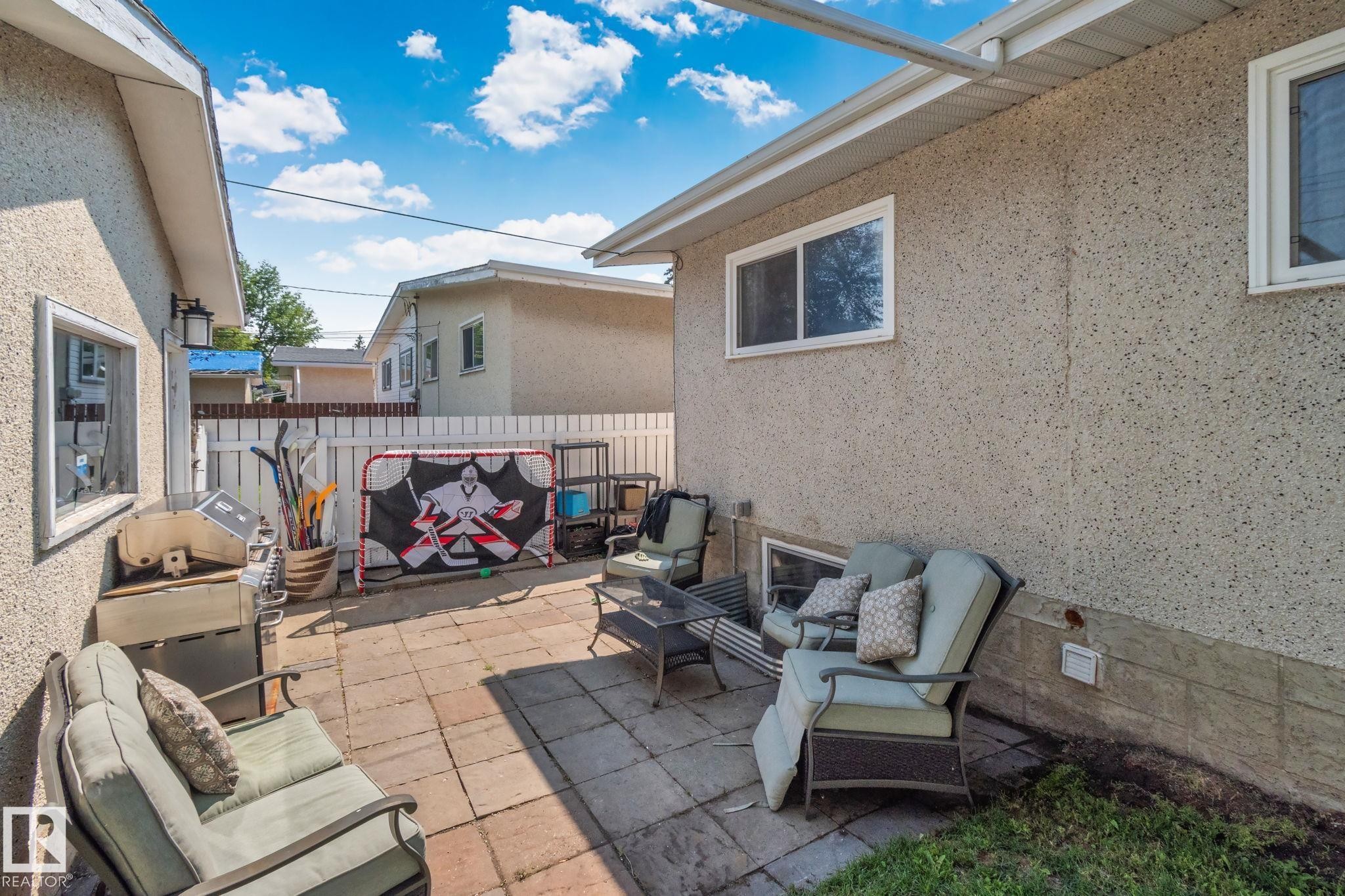 Paved patio area featuring block pavers and a white privacy fence - 4723 105 Street Nw, Edmonton, AB - Outdoor With Deck Patio Veranda With Exterior