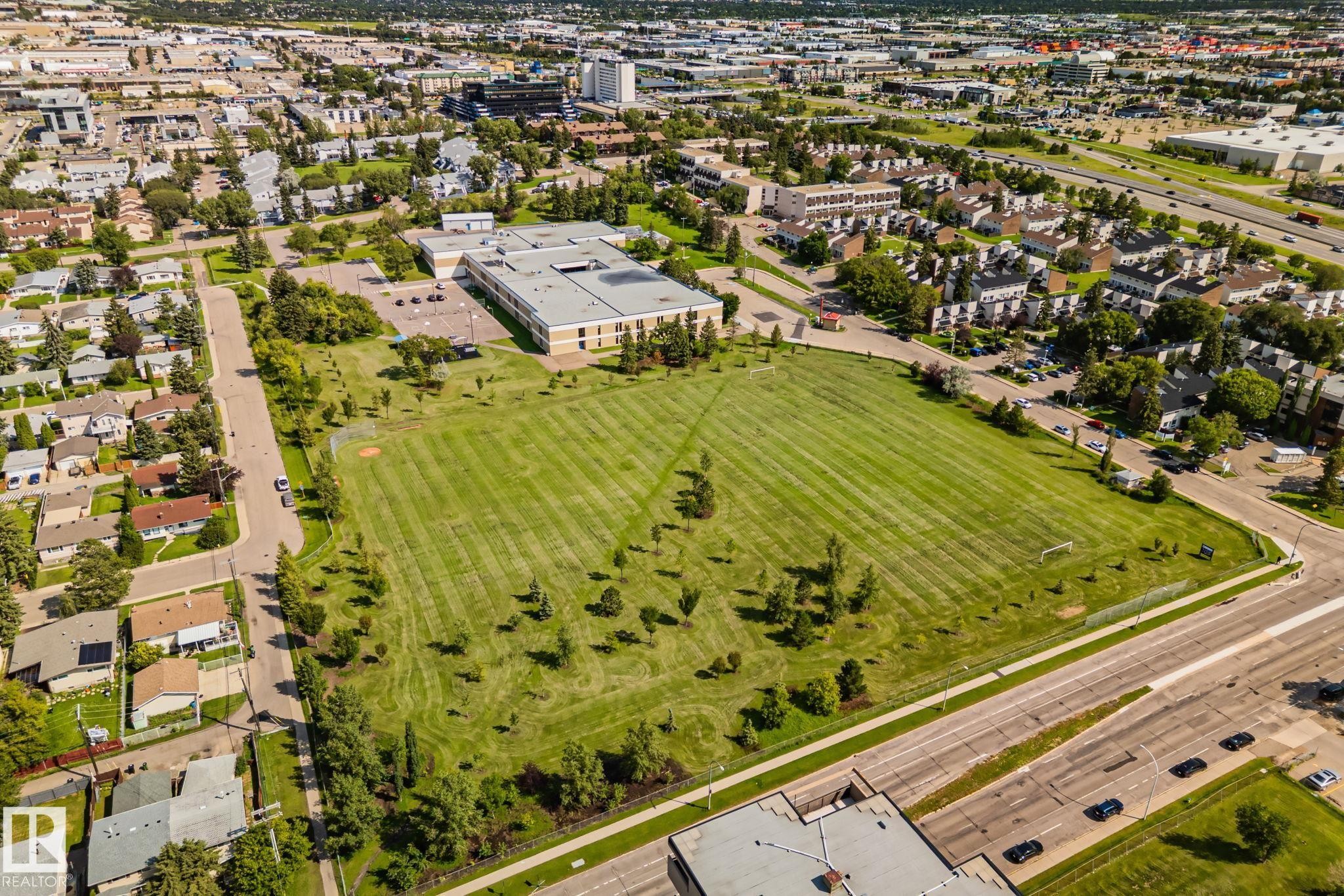 Expansive green space featuring a large manicured lawn with interspersed mature trees - 4723 105 Street Nw, Edmonton, AB - Outdoor With View