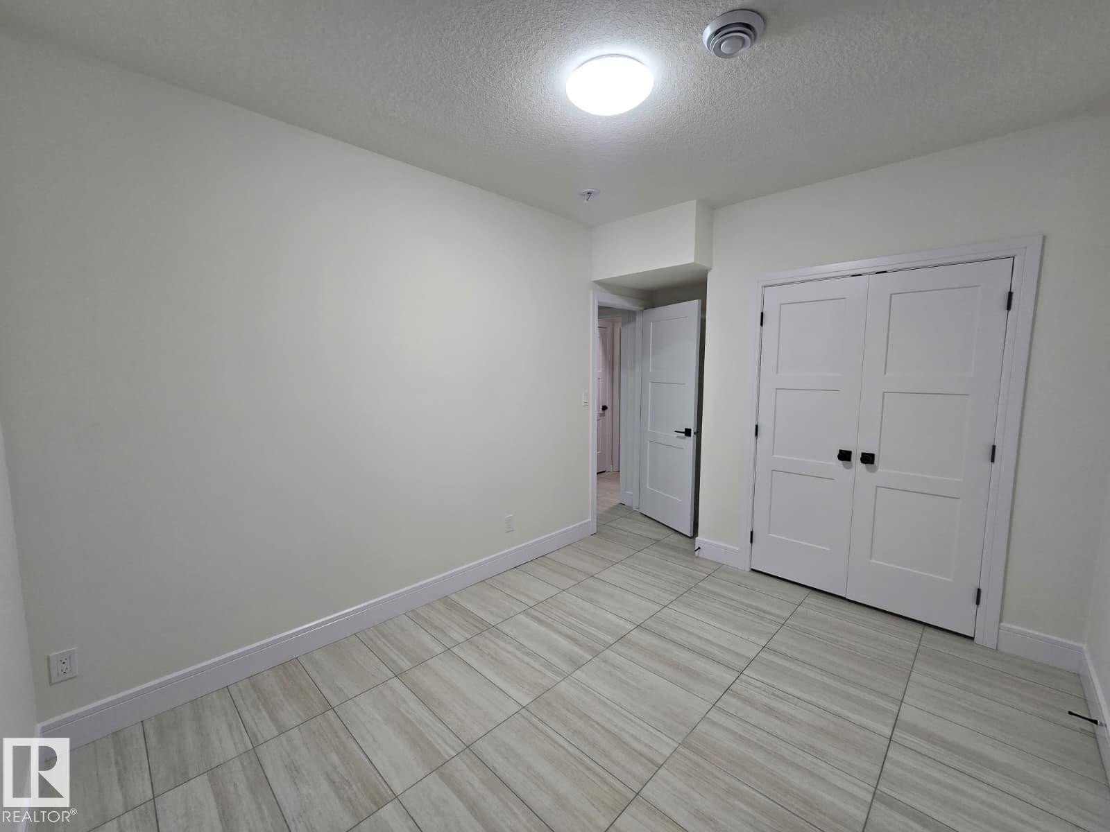 Light-toned tile flooring throughout - 228 36 Street Sw, Edmonton, AB - Indoor Photo Showing Other Room