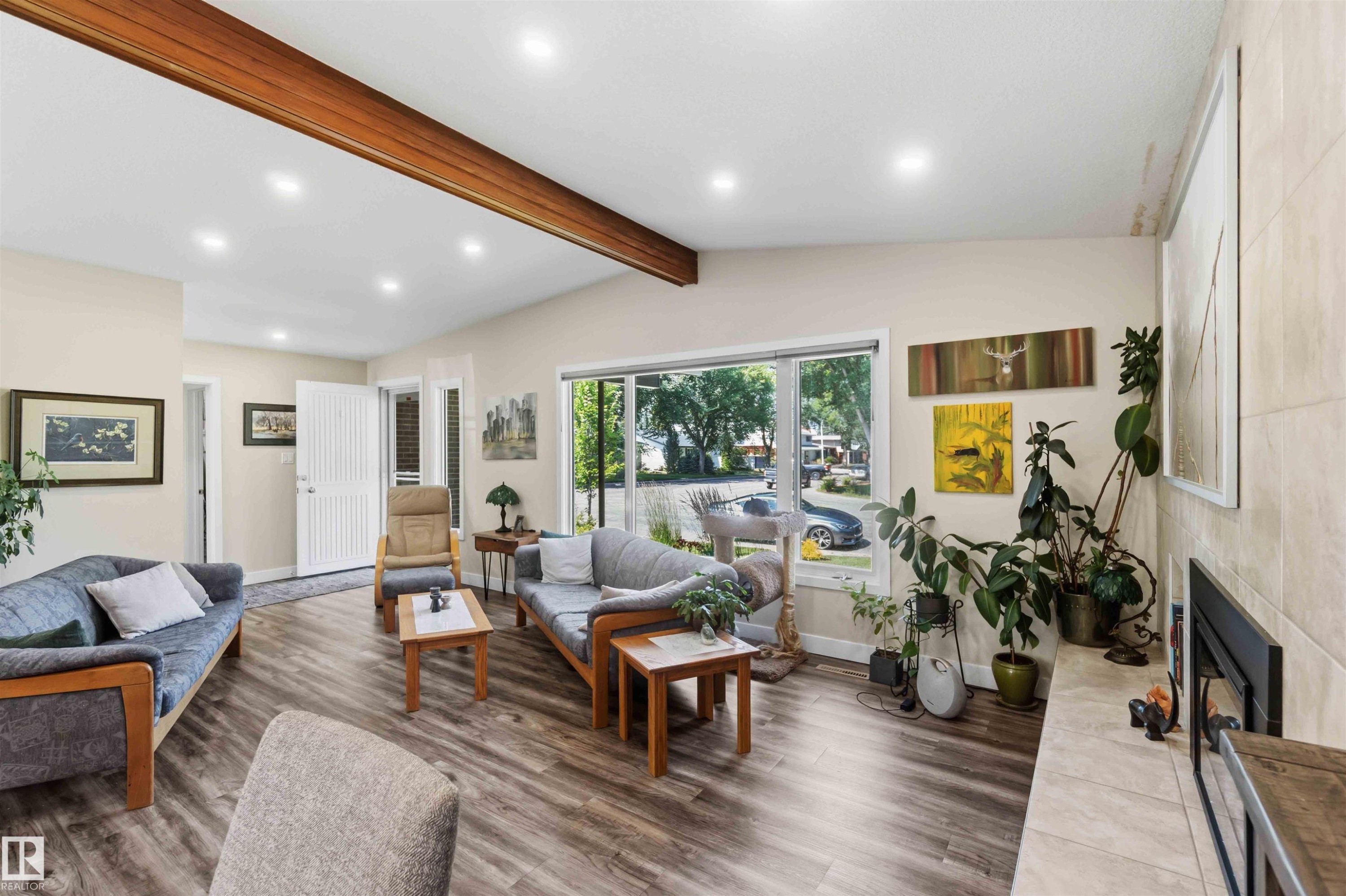 Spacious living area featuring wood-finish flooring, recessed lighting, and a prominent exposed beam - 11351 35A Avenue Nw, Edmonton, AB - Indoor Photo Showing Living Room