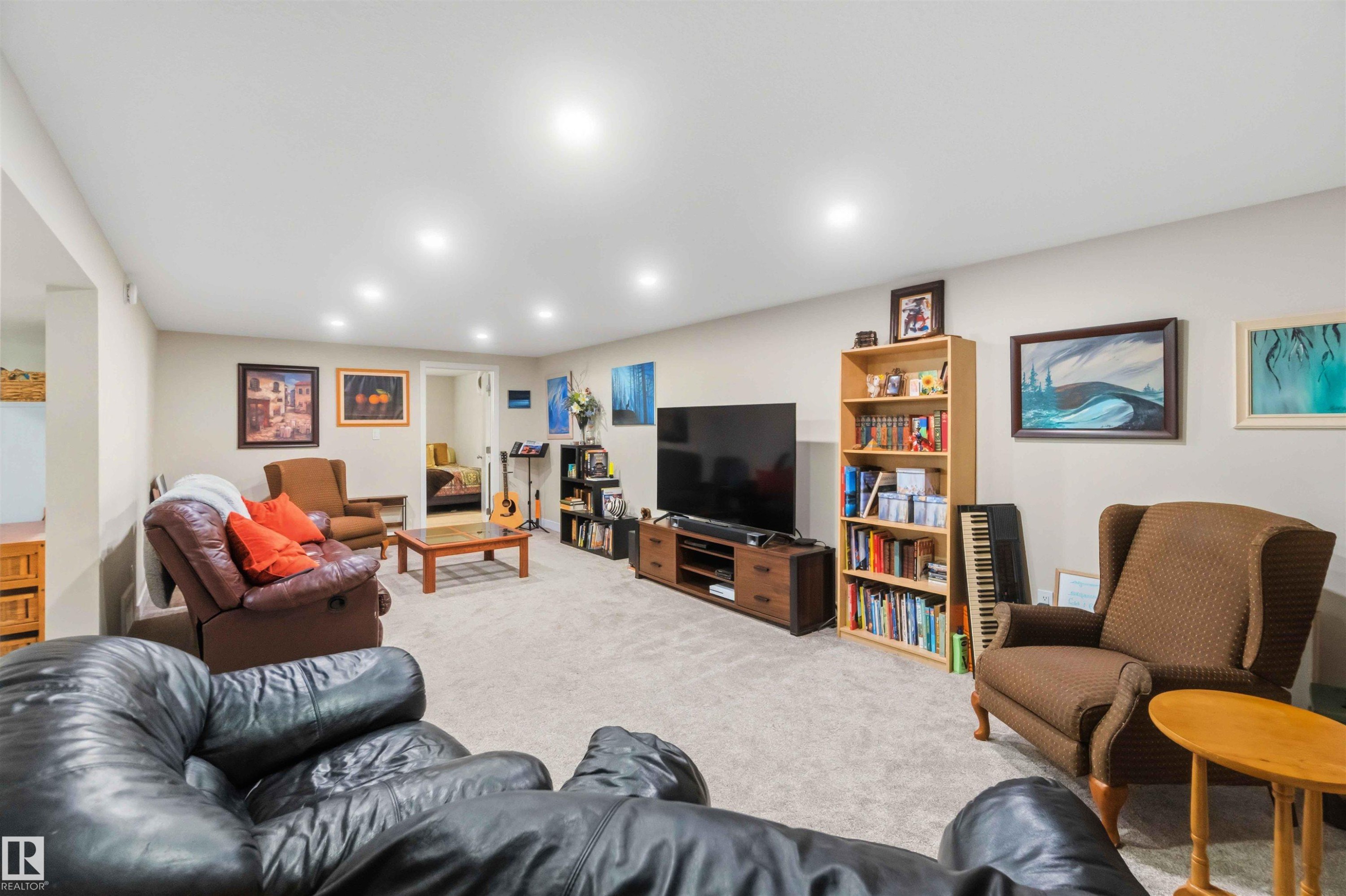 Spacious recreation room featuring recessed lighting, light-toned carpeting, and neutral wall paint - 11351 35A Avenue Nw, Edmonton, AB - Indoor Photo Showing Basement