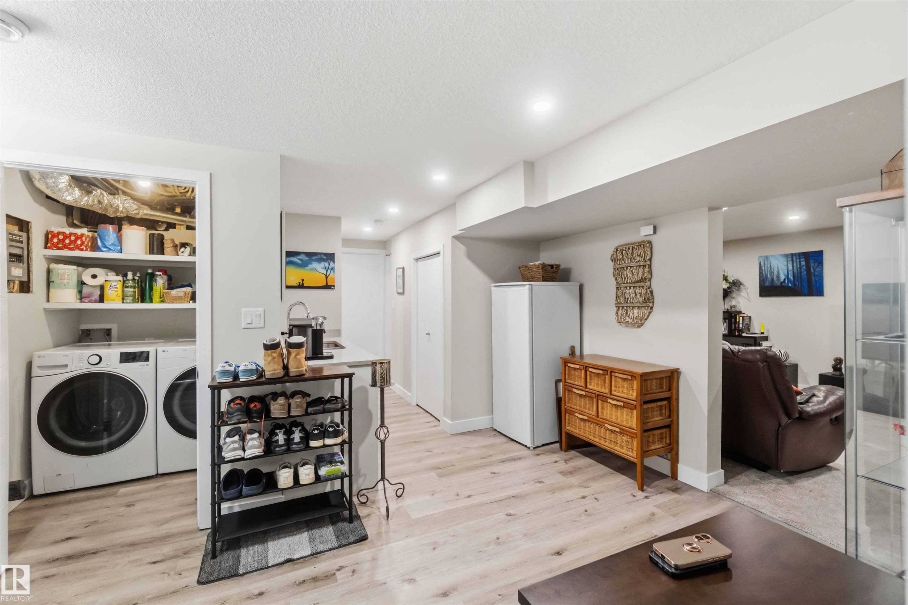 Dedicated laundry area featuring front-loading machines and built-in shelving - 11351 35A Avenue Nw, Edmonton, AB - Indoor Photo Showing Laundry Room