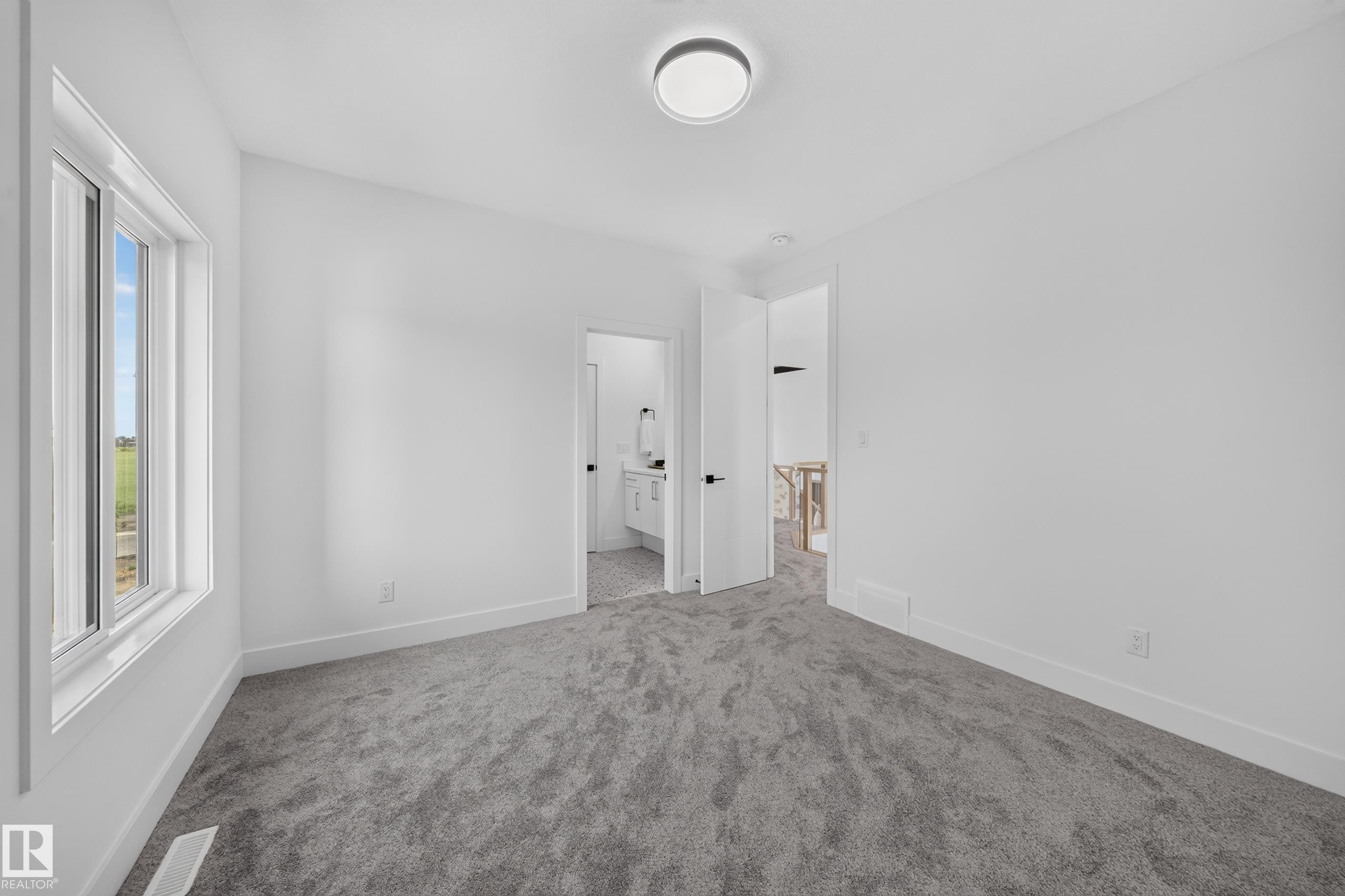 Carpeted room with a ceiling-mounted light fixture and a single window - 423 Robinson Bv, Leduc, AB - Indoor Photo Showing Other Room