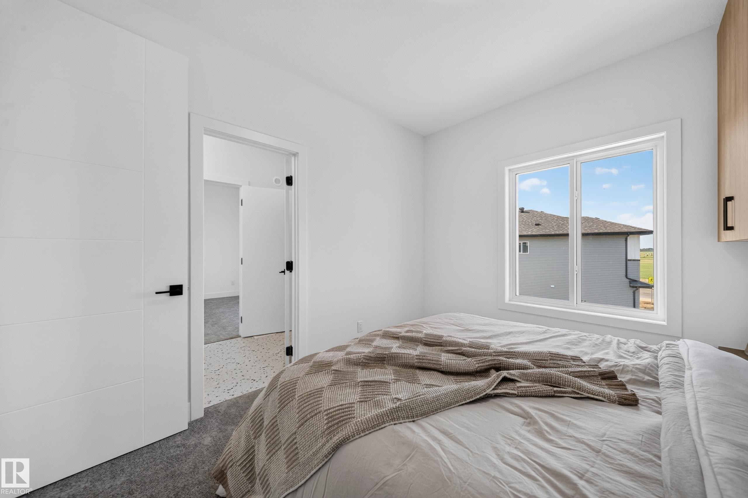 Bright interior with white walls, a multi-pane window, and light grey carpeting - 423 Robinson Bv, Leduc, AB - Indoor Photo Showing Bedroom