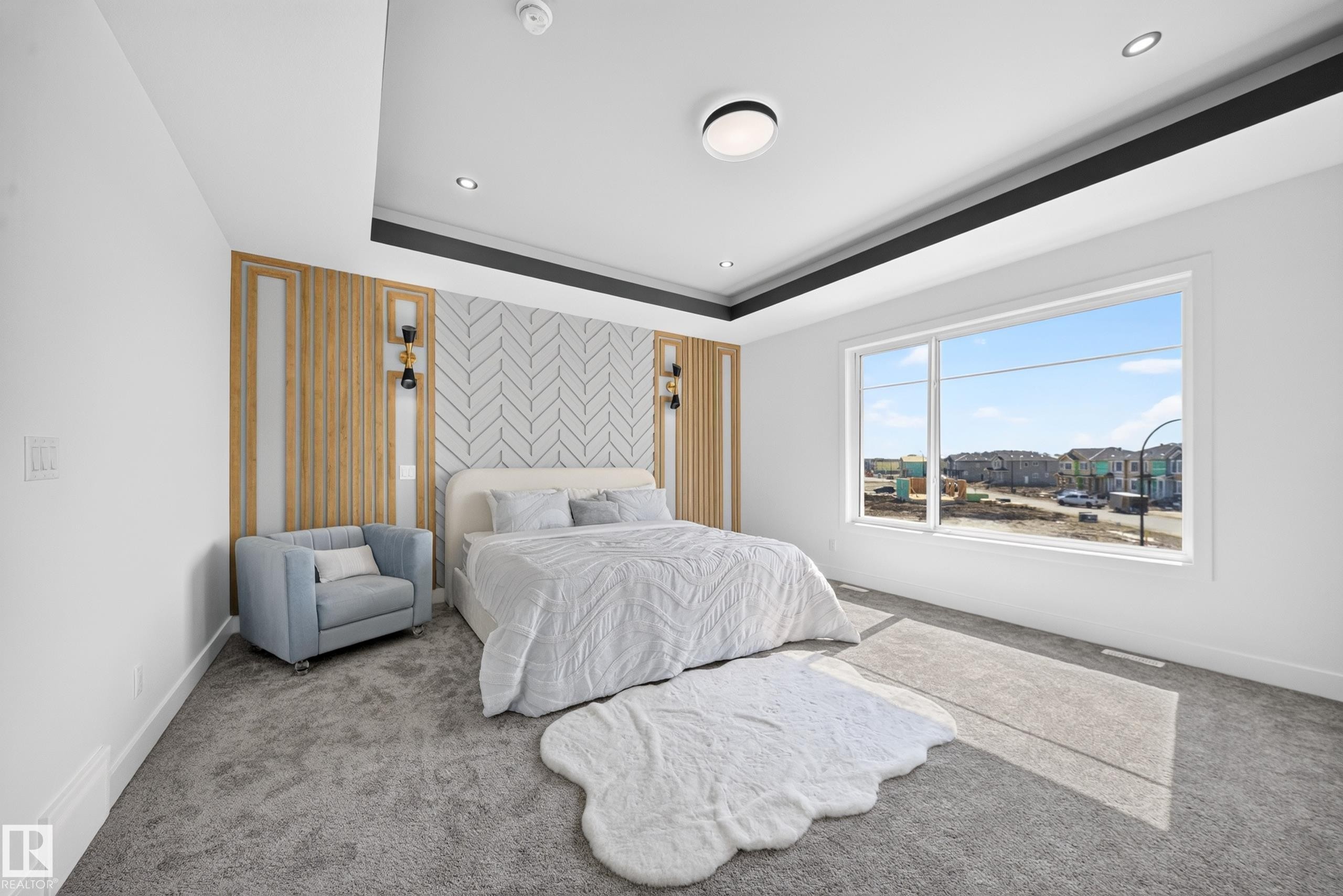 Expansive bedroom featuring a tray ceiling with recessed lighting, a large window, and patterned accent wall - 423 Robinson Bv, Leduc, AB - Indoor Photo Showing Bedroom