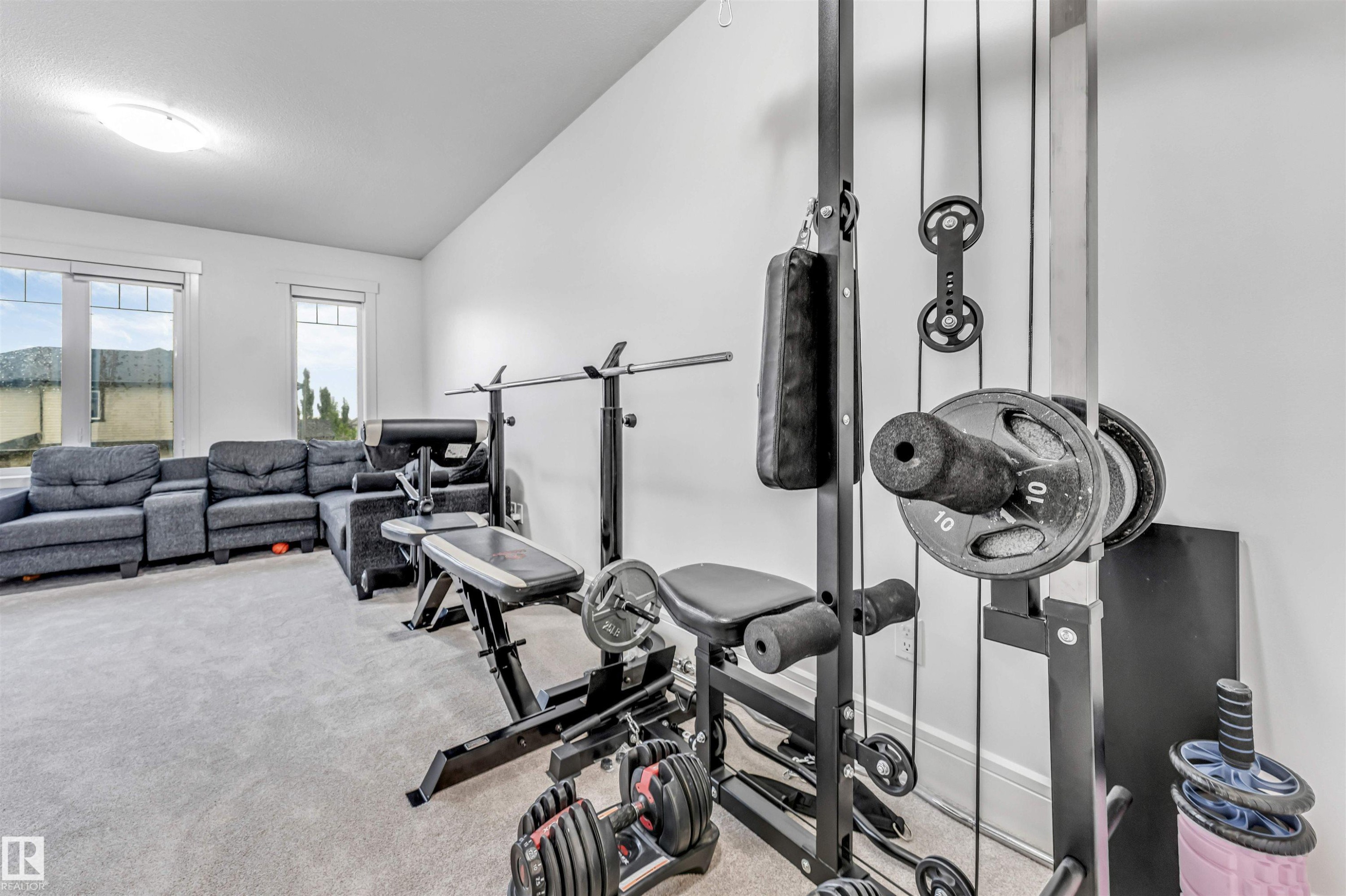 Spacious room with light-colored carpet flooring and white walls, featuring two large windows - 6727 20 Ave Sw, Edmonton, AB - Indoor