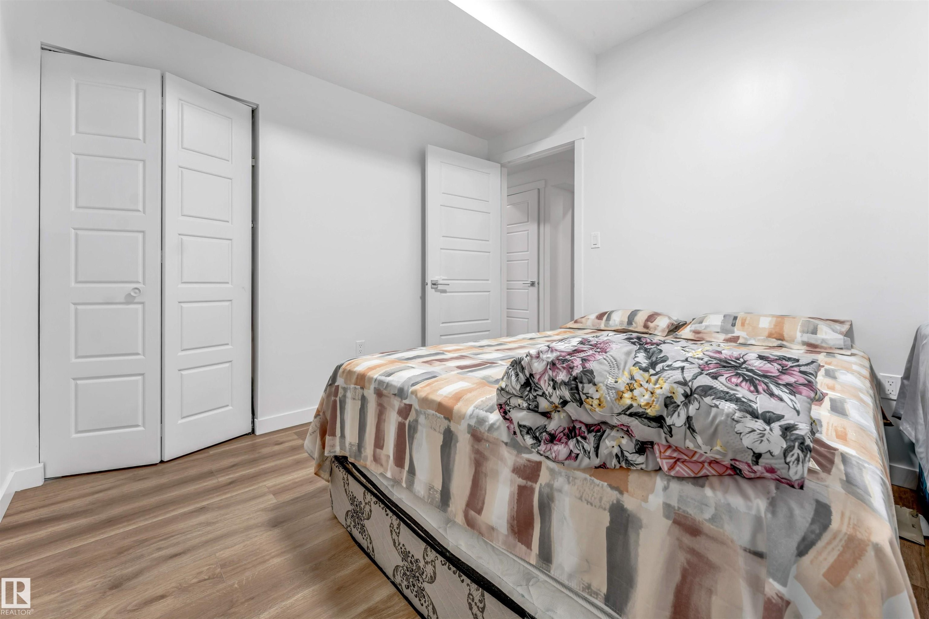 Bright bedroom featuring wood-finish flooring and white walls - 6727 20 Ave Sw, Edmonton, AB - Indoor Photo Showing Bedroom