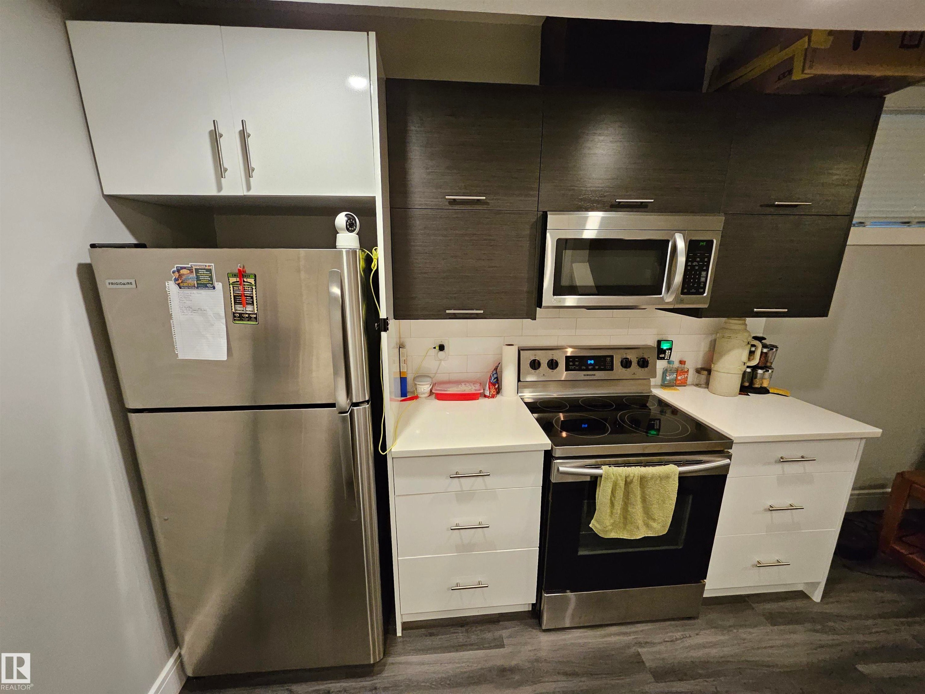 Compact kitchen featuring a stainless steel refrigerator and range - 9311 66 Avenue Nw, Edmonton, AB - Indoor Photo Showing Kitchen
