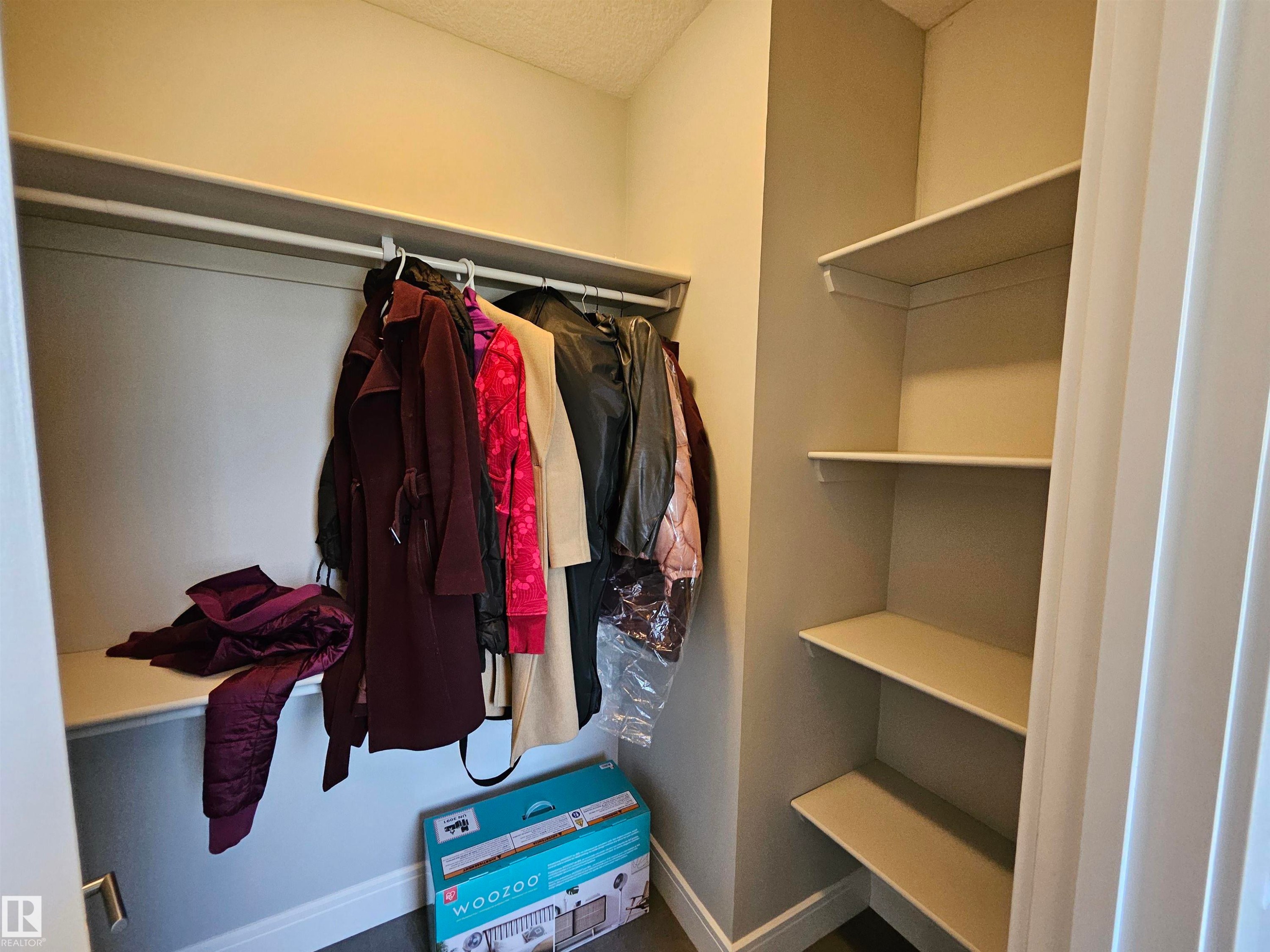 Entryway closet featuring a built-in hanging rod, upper shelf, and three side shelves - 9311 66 Avenue Nw, Edmonton, AB - Indoor With Storage