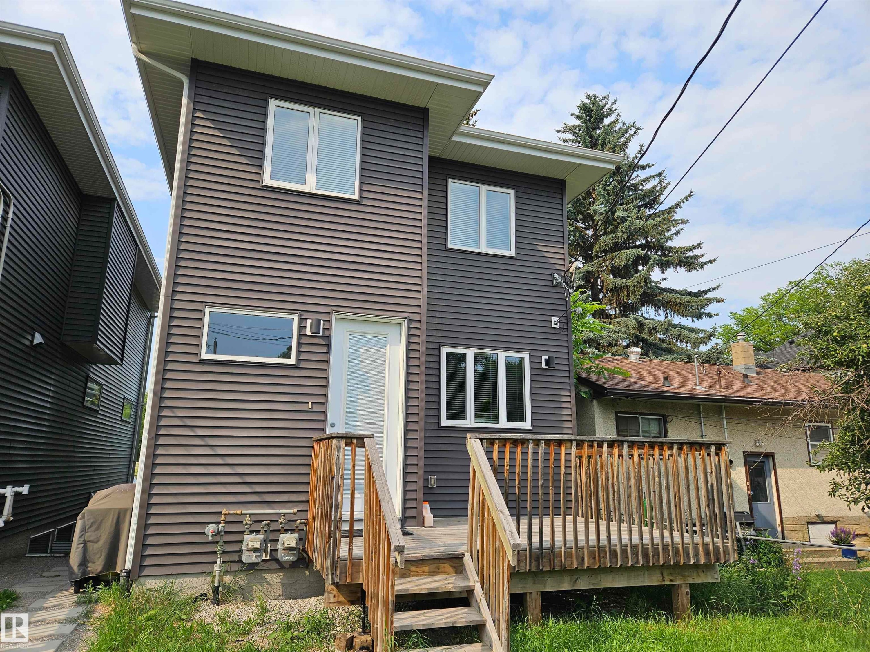 Modern exterior featuring dark horizontal siding and white window frames - 9311 66 Avenue Nw, Edmonton, AB - Outdoor