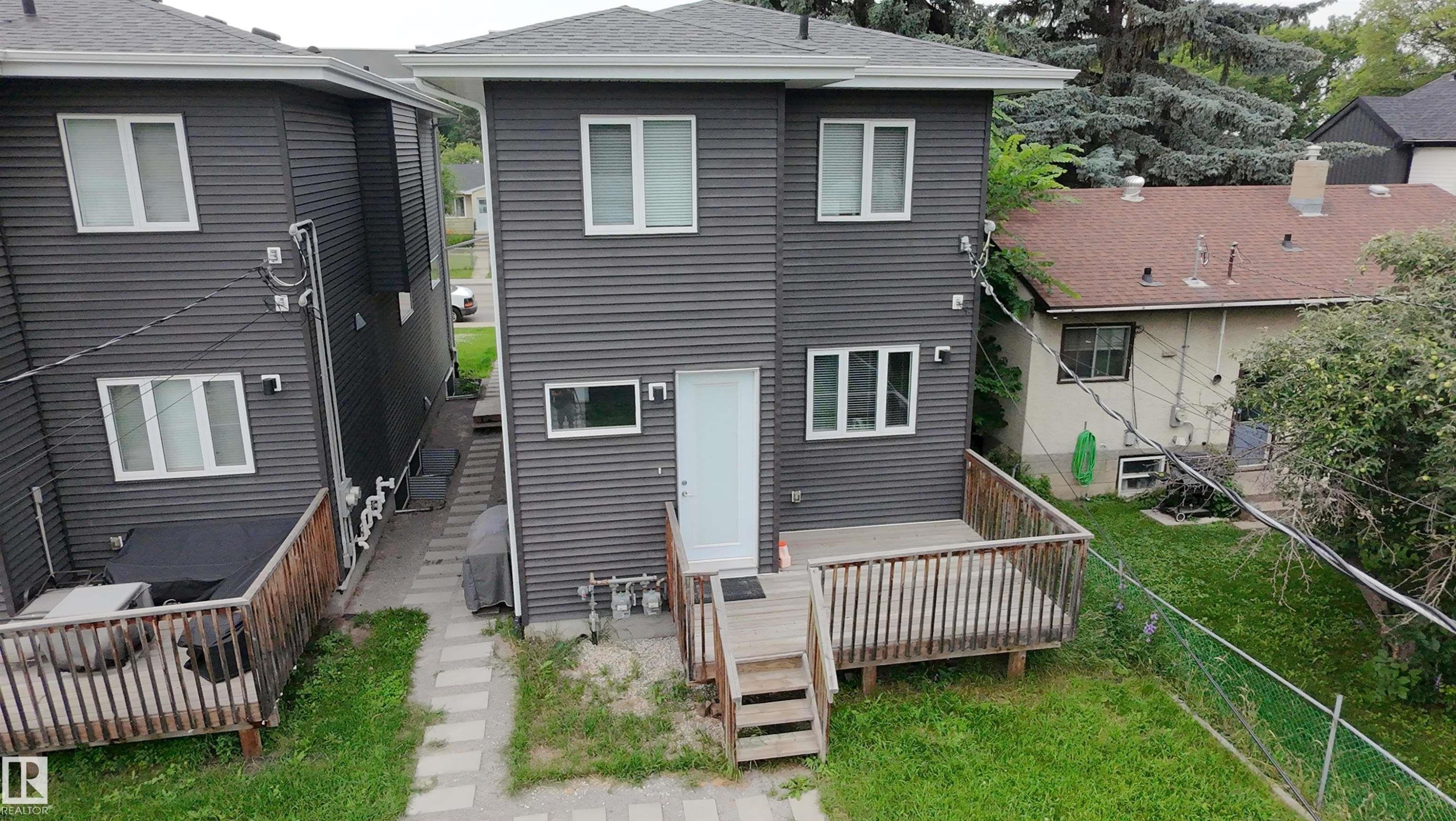 Two-story residence featuring contemporary dark gray siding and white-framed windows - 9311 66 Avenue Nw, Edmonton, AB - Outdoor
